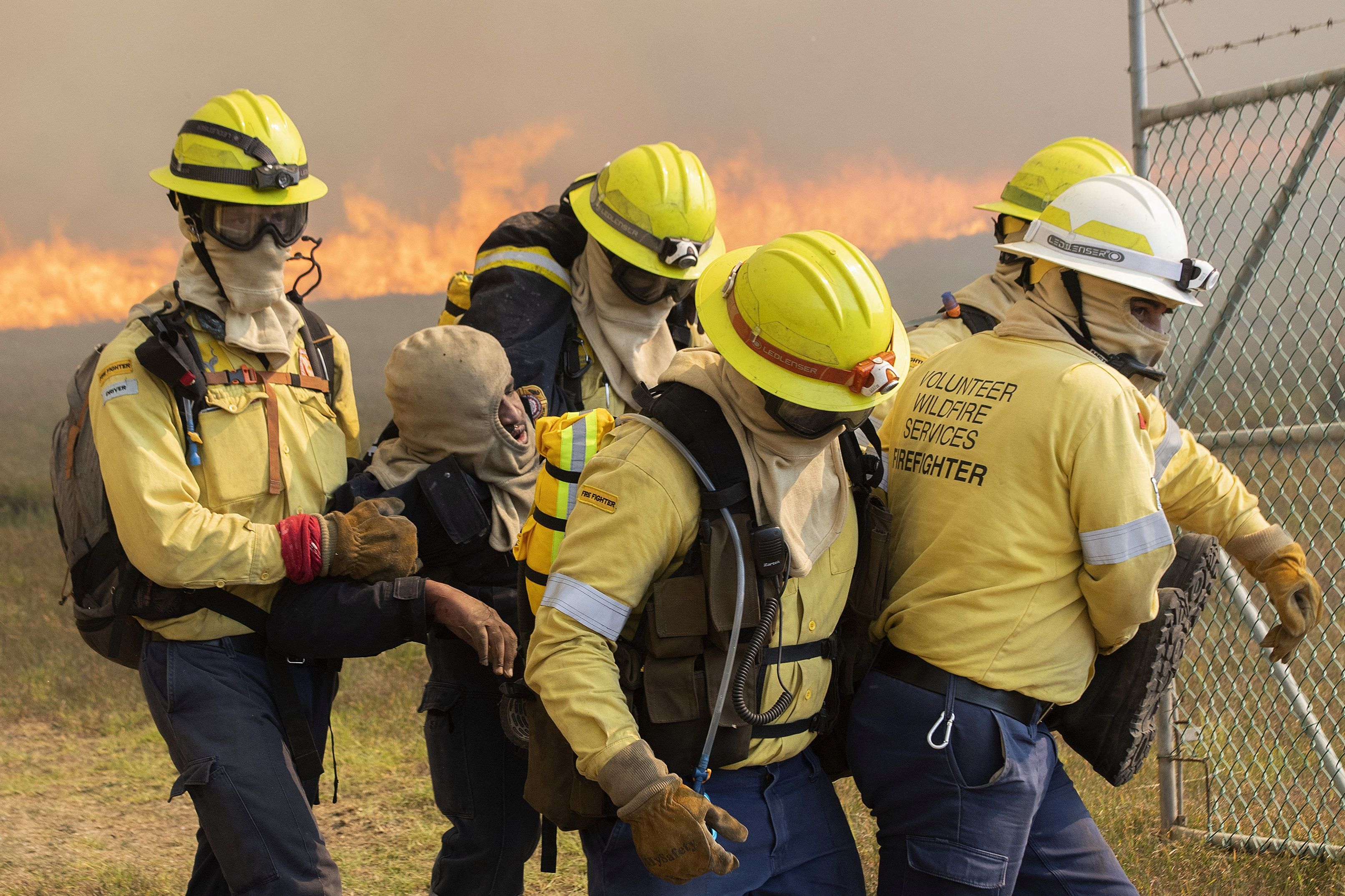  Firefighters carry a colleague who collapsed due to the smoke and the heat, as a forest fire burns out of control on the foothills of Table Mountain in Cape Town