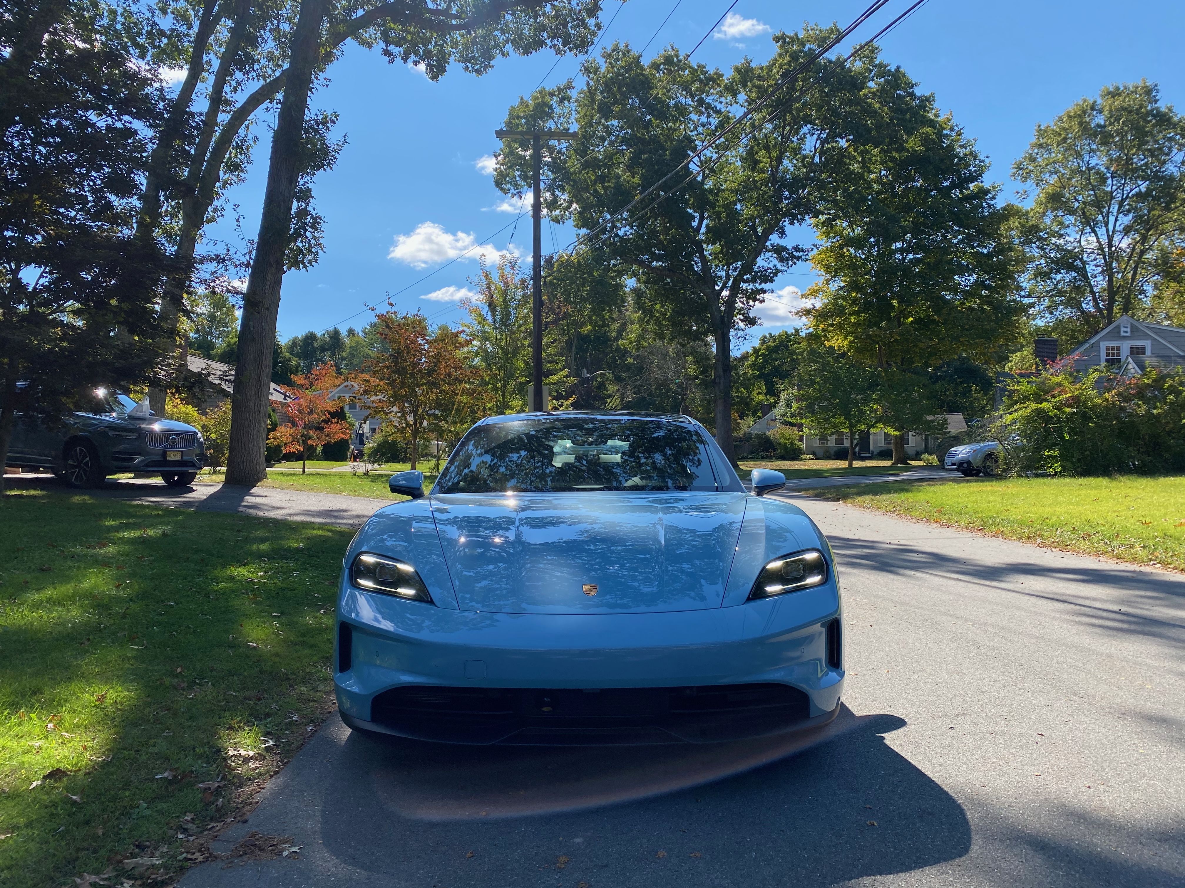 A photo of the front of an electric blue Porsche Taycan EV.