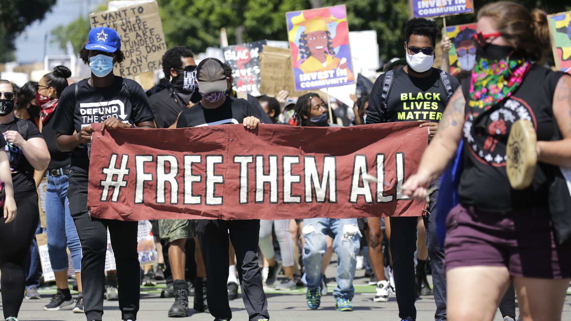 Protestors carry a "Free Them All" banner during a "Defund the Police" march from King County Youth Jail to City Hall in Seattle, Washington on August 5