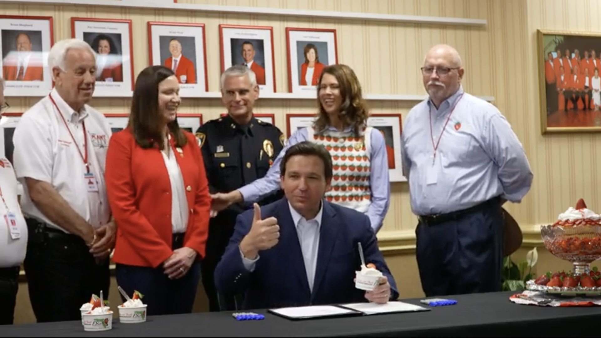 Gov. DeSantis gives a thumbs up while holding a cup of strawberry shortcake.