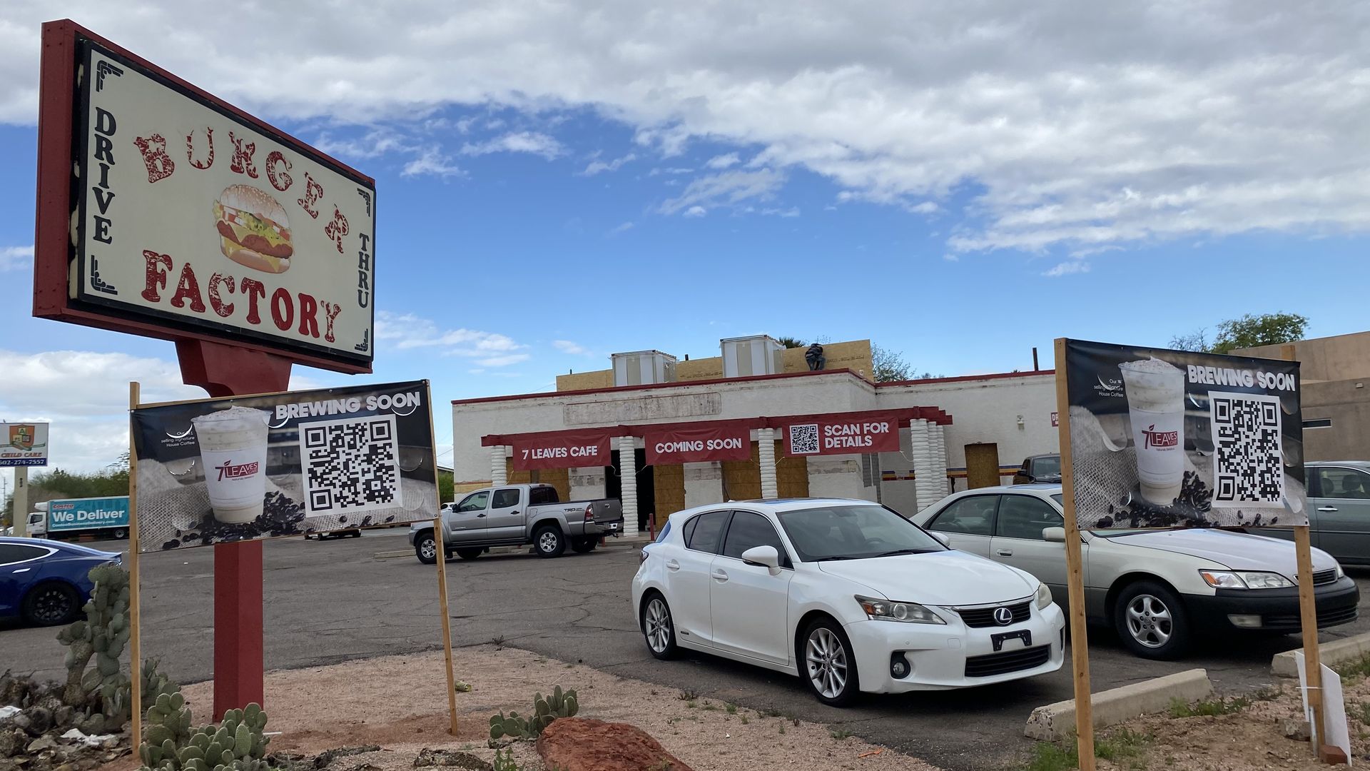 A boarded up restaurant under renovation with a sign that says Burger Factory. 