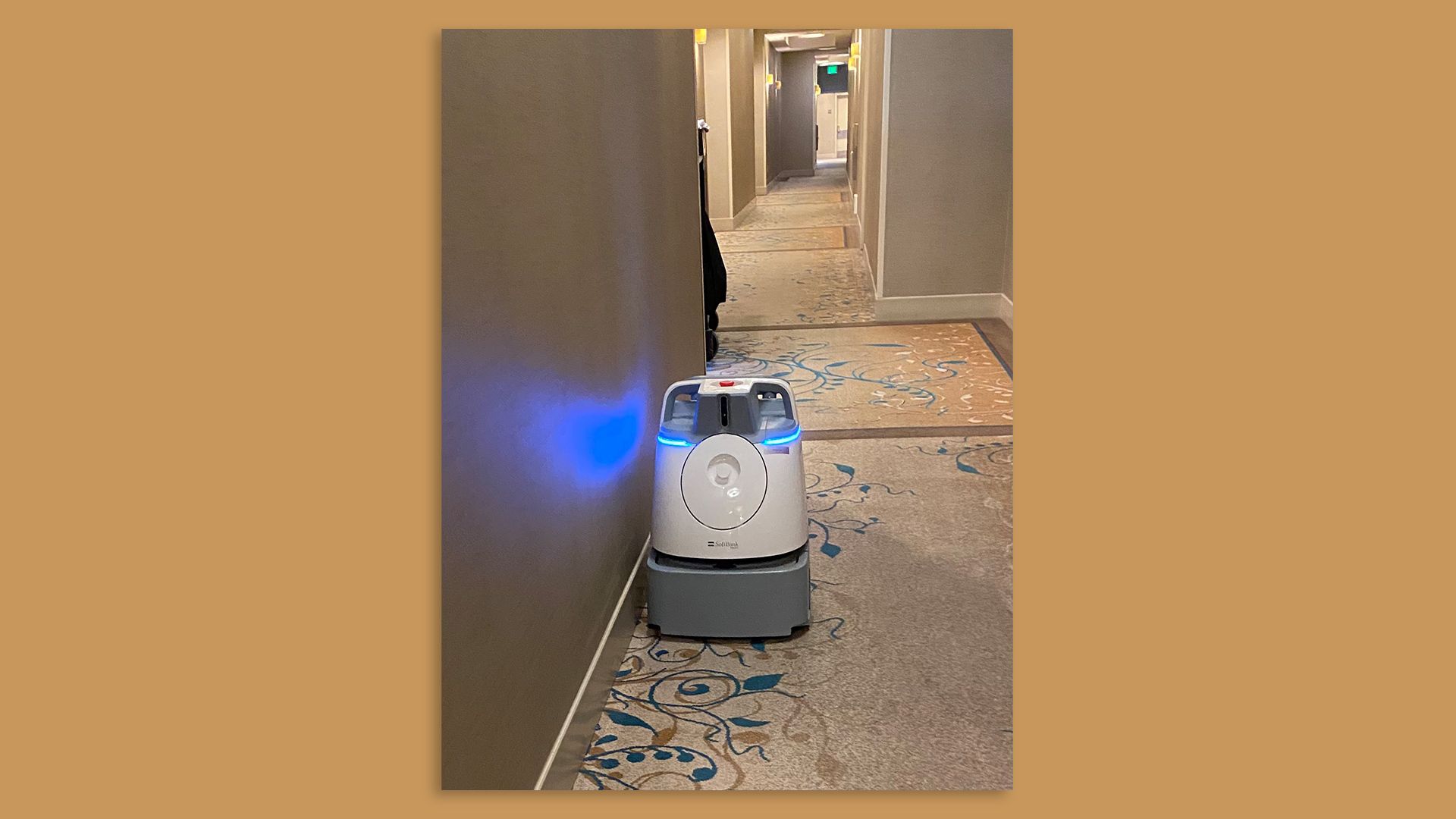 A robot carpet cleaner in a hotel hallway