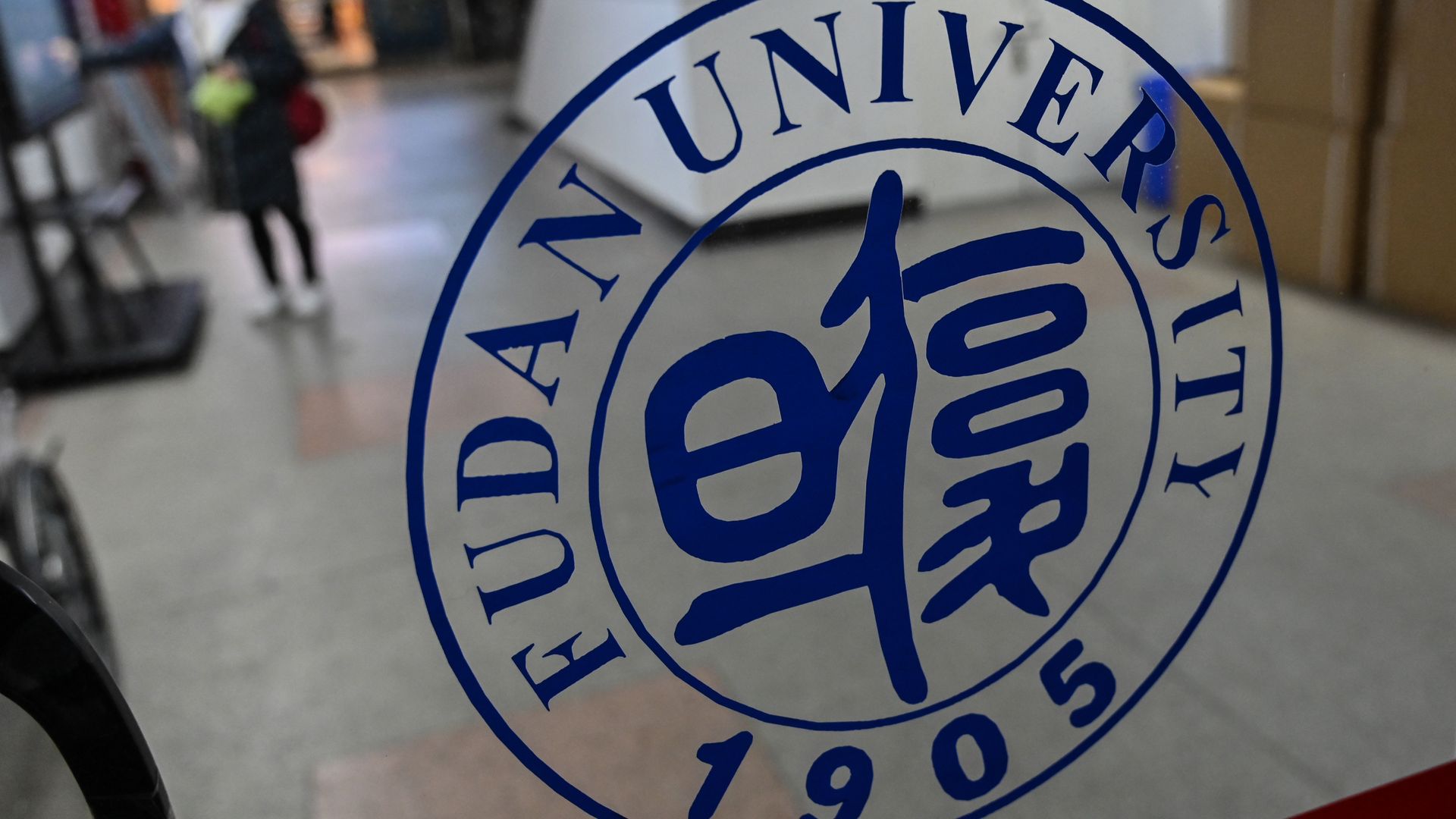 Fudan University's logo embossed on a glass door