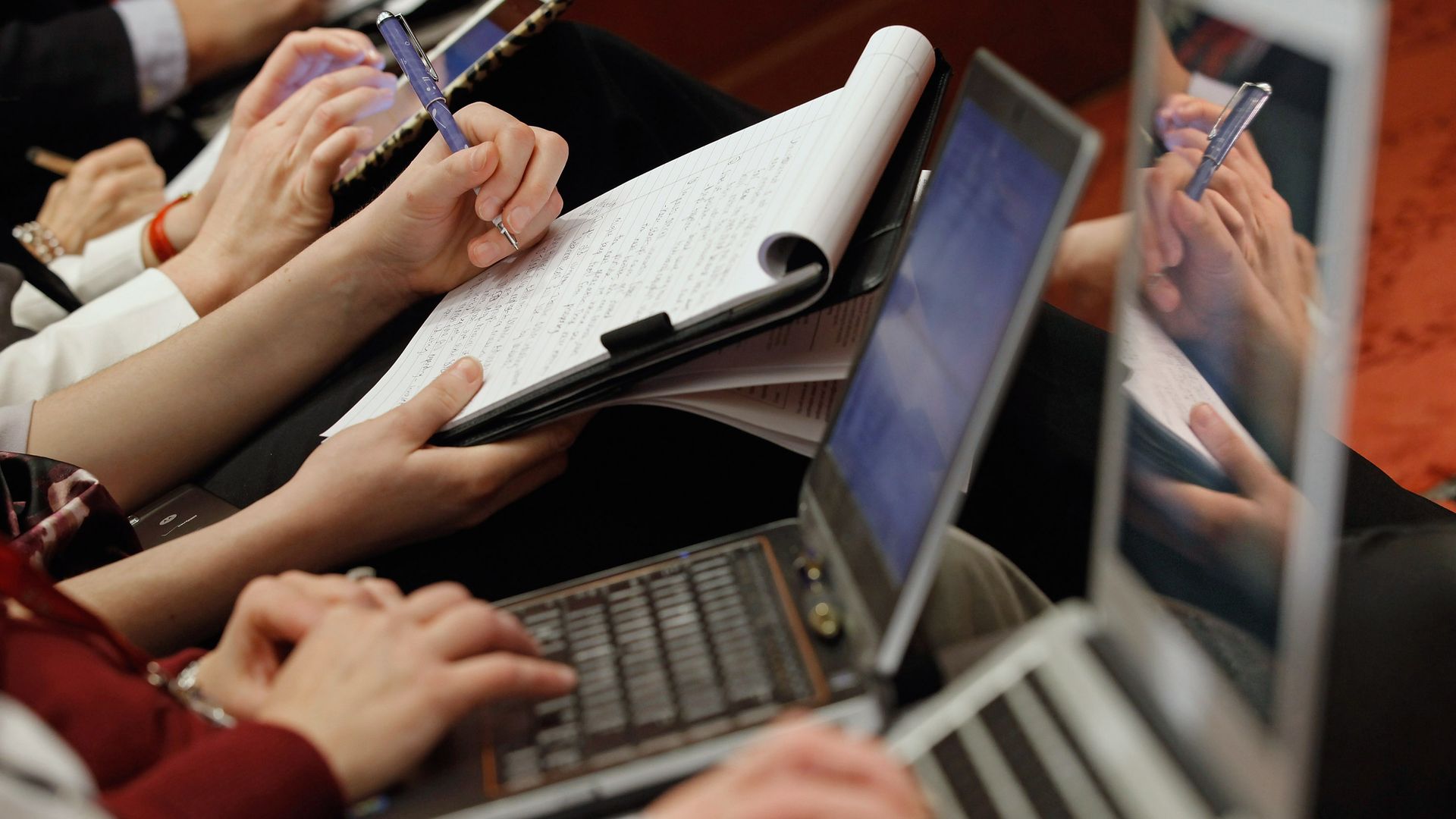People typing and taking notes