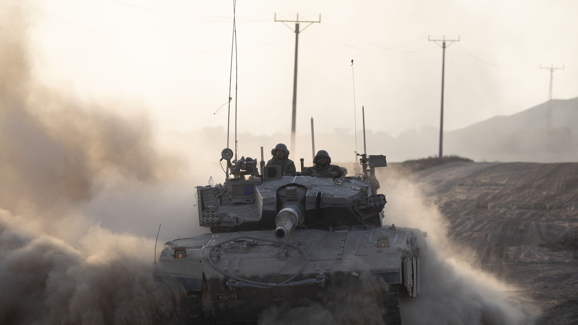 Israeli soldiers in a tank as it drives along the border with the Gaza Strip on August 7, 2024 in Southern Israel,