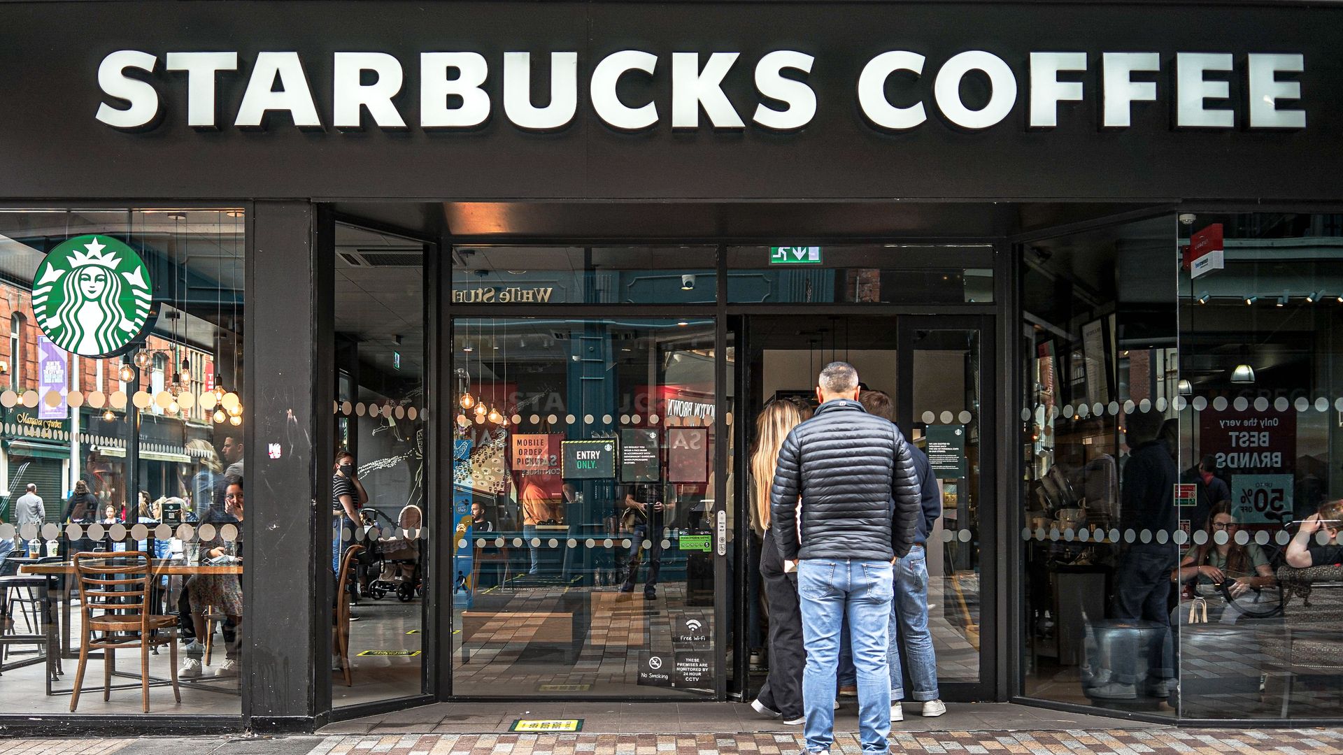 Customers line up to enter Starbucks Coffee in the U.K.