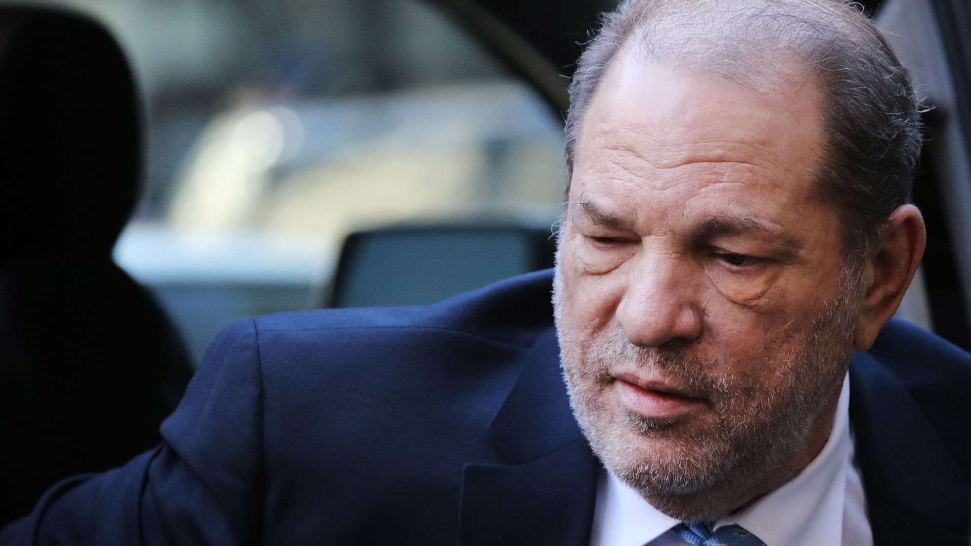 This image is a close-up of Harvey Weinstein as he gets out of a car