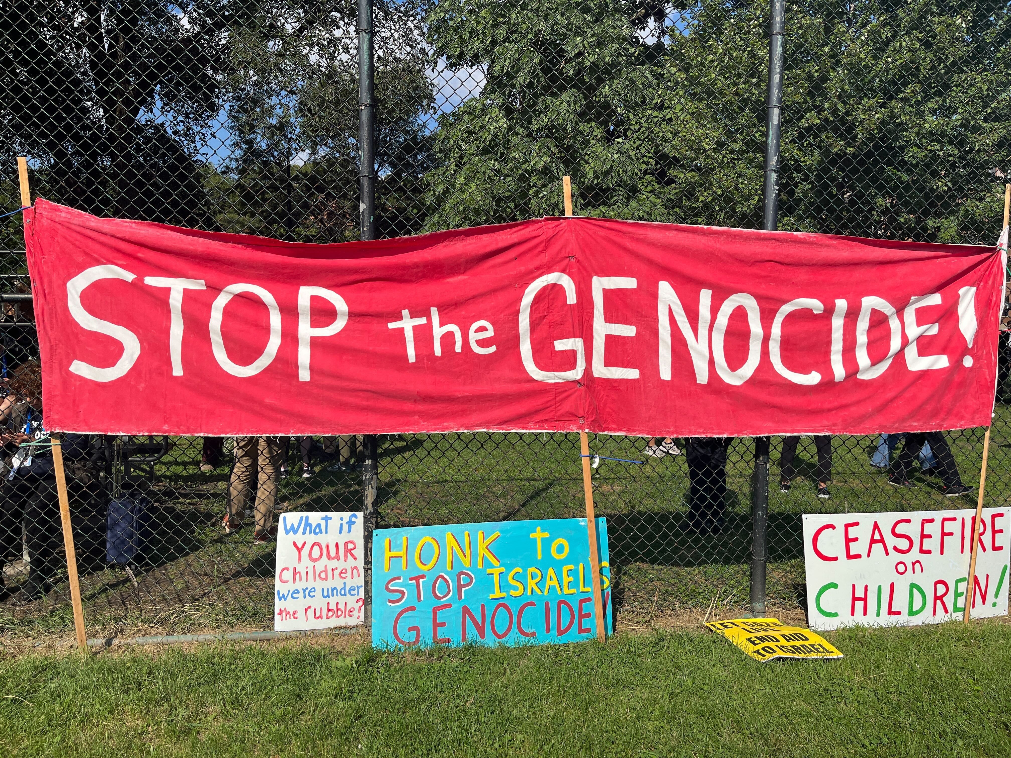 stop the genocide banner hangs on a fence