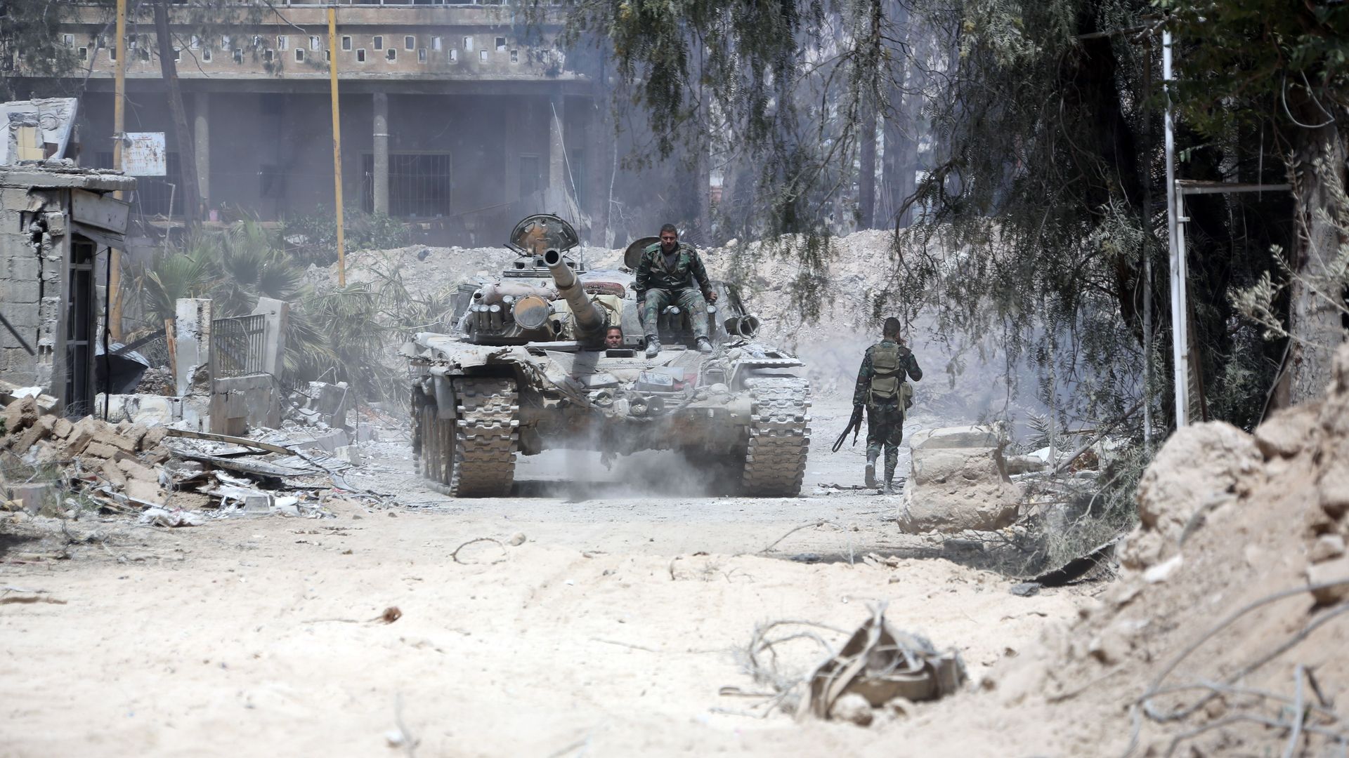 Syrian Army soldiers advance in an area on the eastern outskirts of Douma