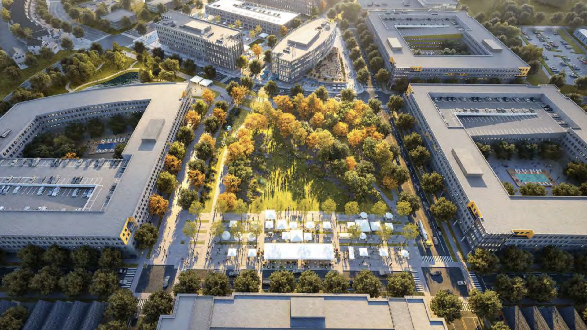 An aerial view of a modern campus: a sunlit central park with orange autumn trees, enclosed by large U-shaped buildings, surrounding roads, and a plaza with white tents.