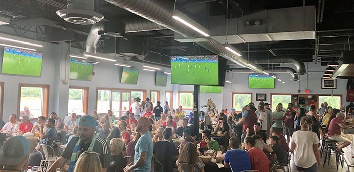 Soccer fans at a brewery watching a game.
