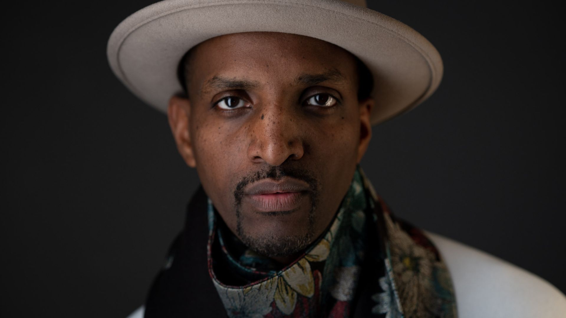 Photo of a man's face. He's wearing a hat. 