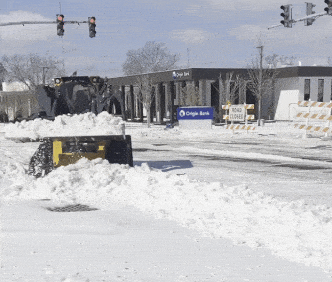 Image shows heavy equipment clearing snow from a road.