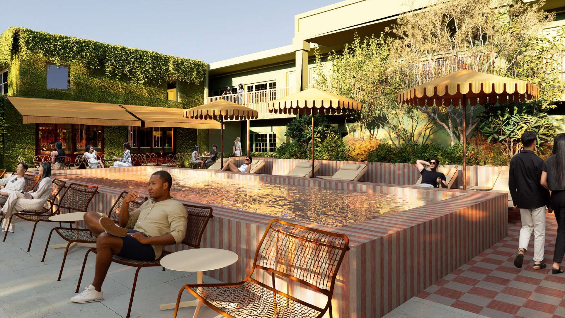Outdoor poolside scene with pink-tiled pool, wicker lounge chairs, and orange canopies. Ivy-covered green building on the left and pale yellow modern building on the right; people relax and chat by the pool.