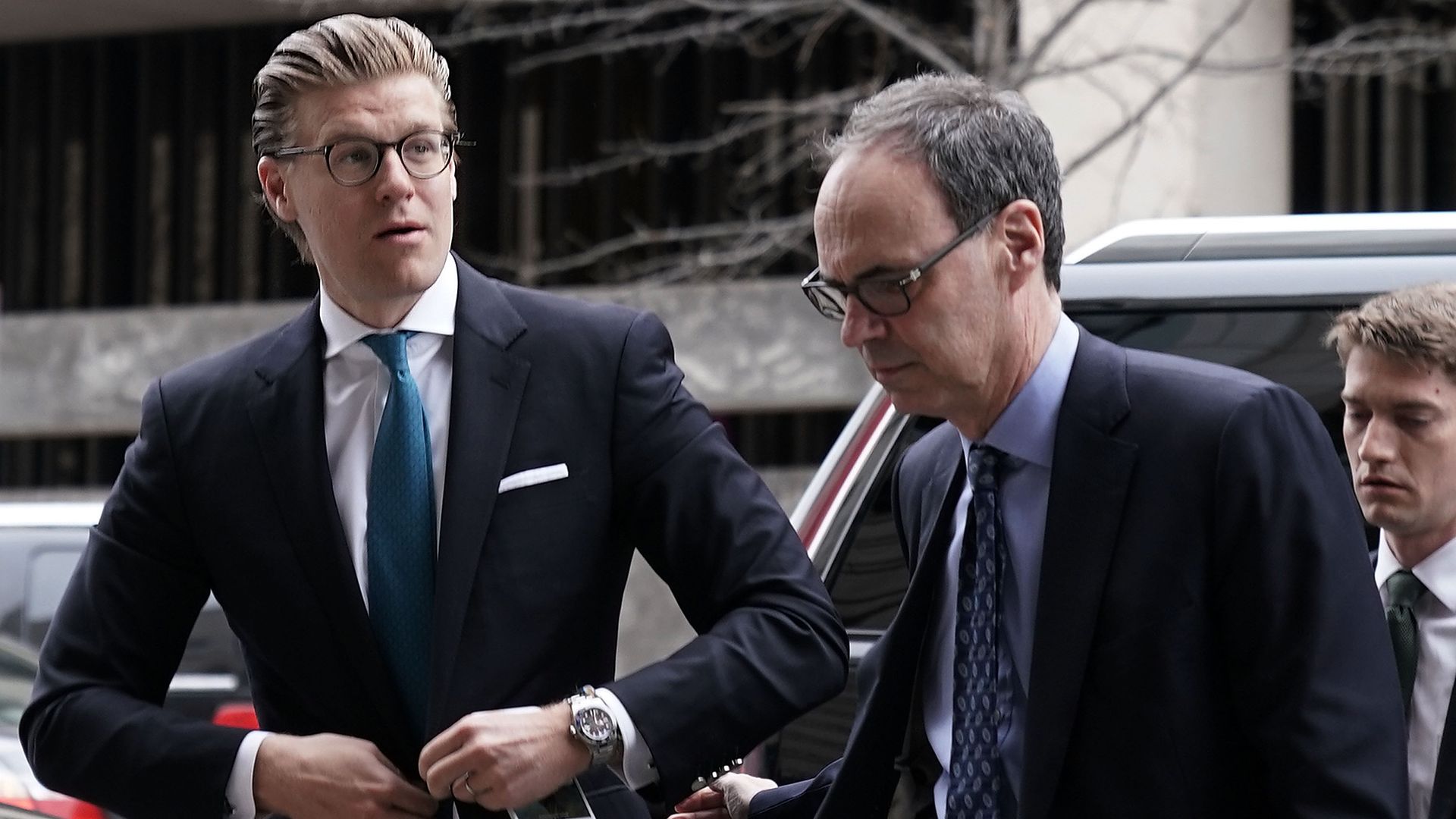 Alex Van Der Zwaan buttons his suit outside a federal courthouse.