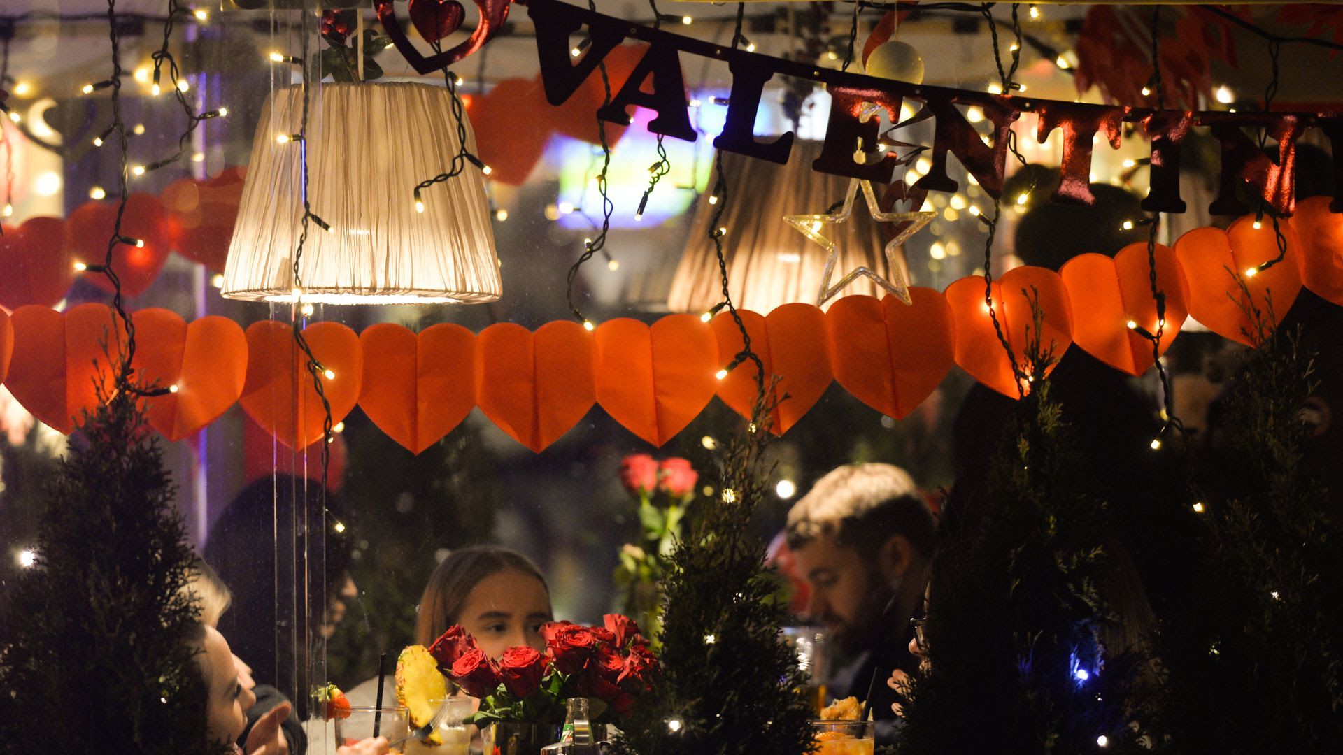People celebrate Valentine's Day in a decorated restaurant.