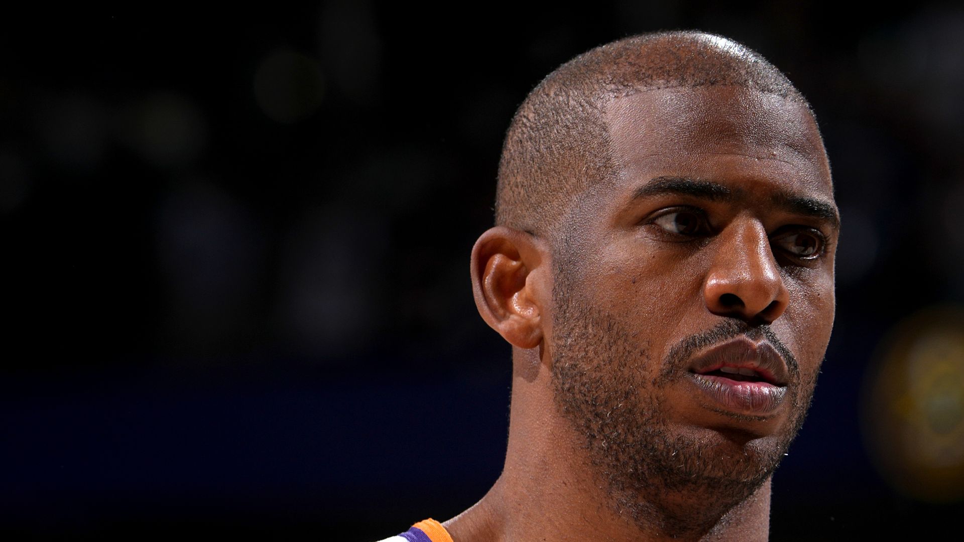 A head shot of a basketball player in a white jersey. 