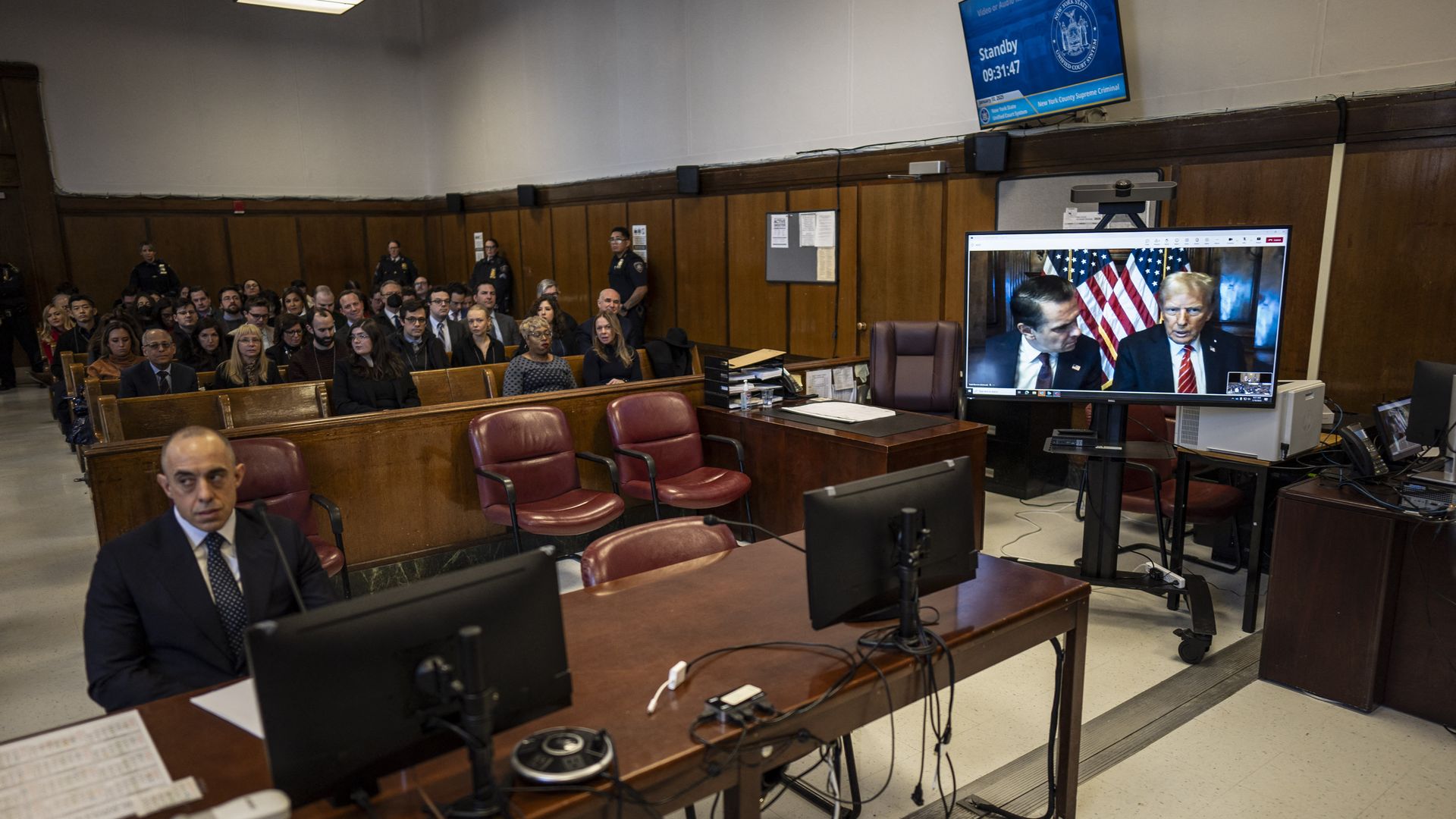 Attorney Todd Blanche and US President-elect Donald Trump, seen on a television screen, appear virtually for sentencing after Trump was found guilty on 34 felony counts in his hush money criminal trial last year, at the Manhattan criminal court on January 10,