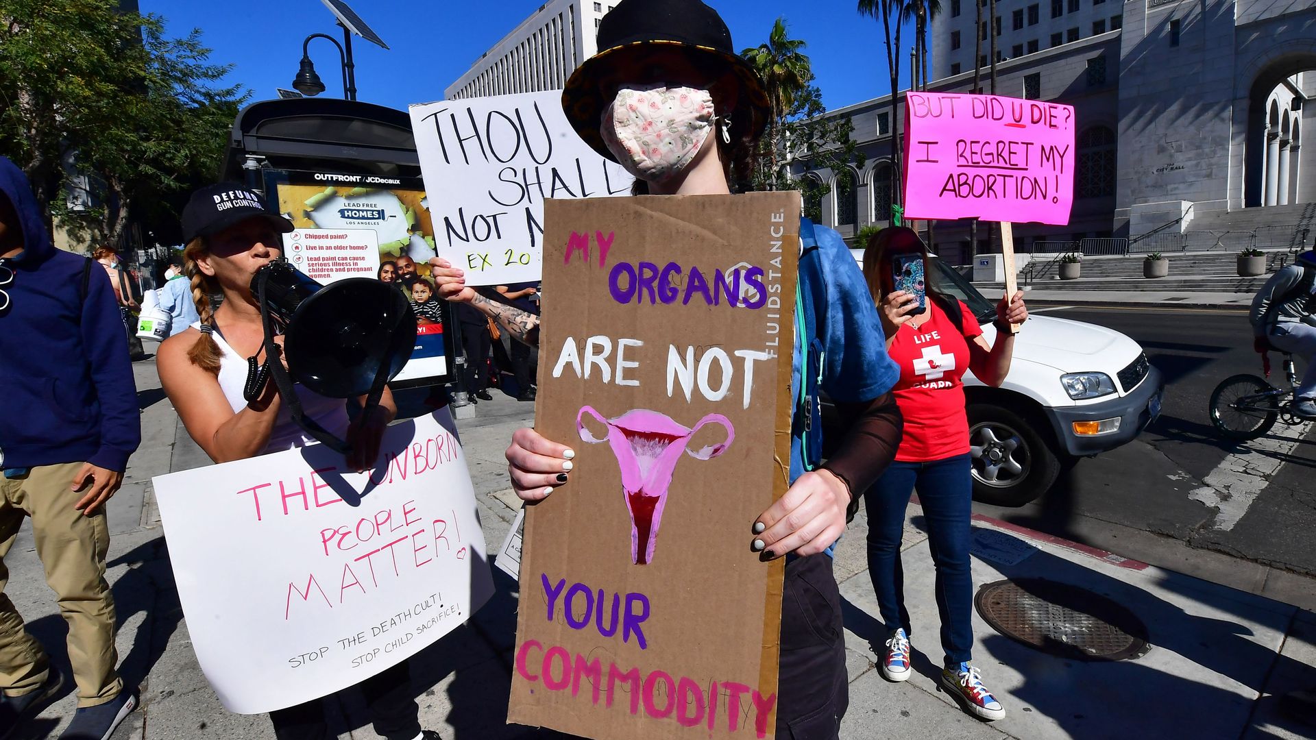 Picture of an abortion rights supporter surrounded by anti-abortion activists.