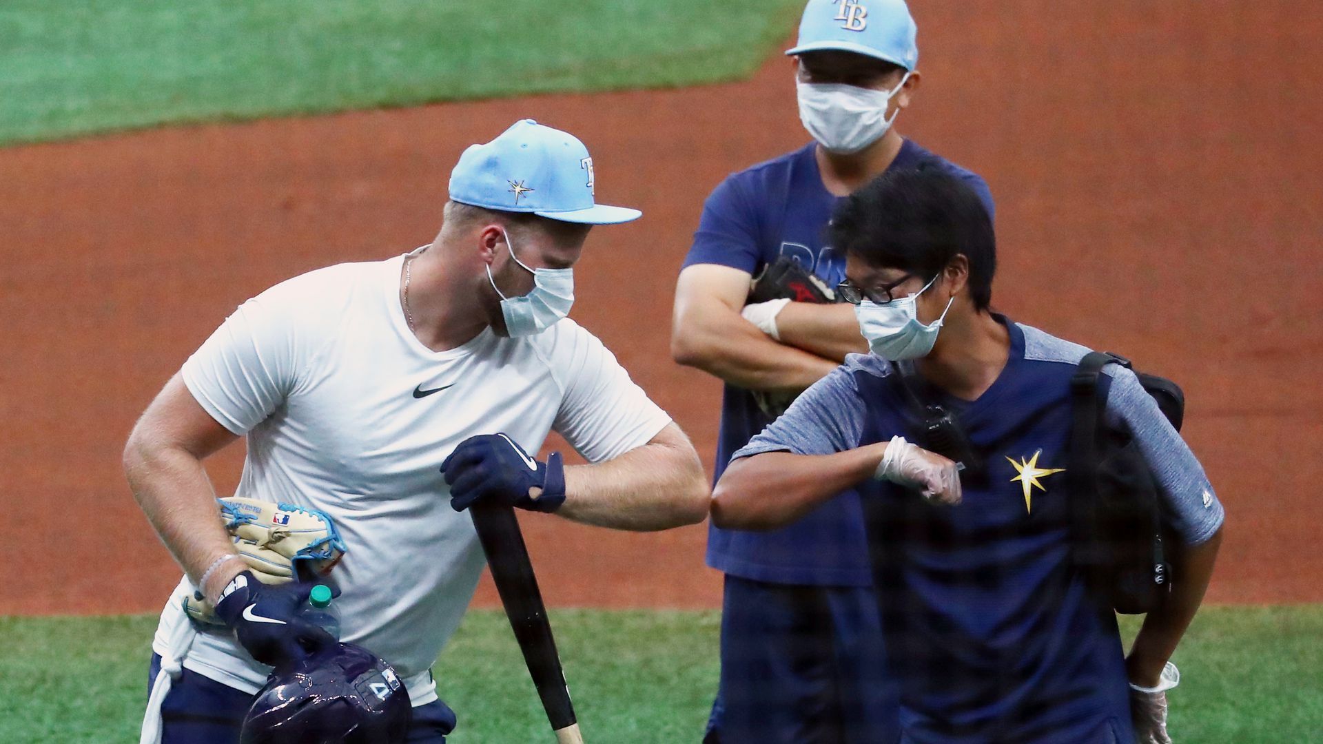 Major League Baseball players elbow bumping during training