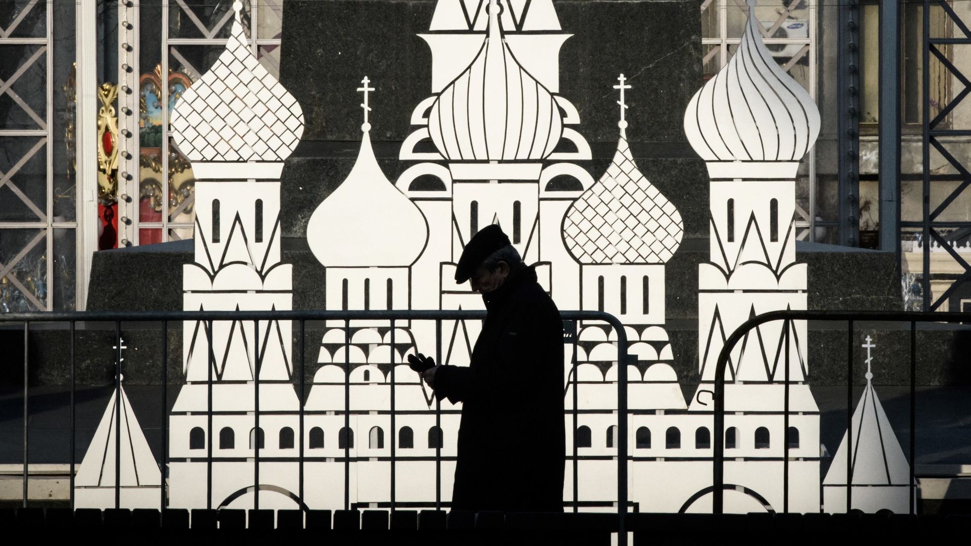 Man walks in front of cardboard cutout of Cathedral of St. Basil