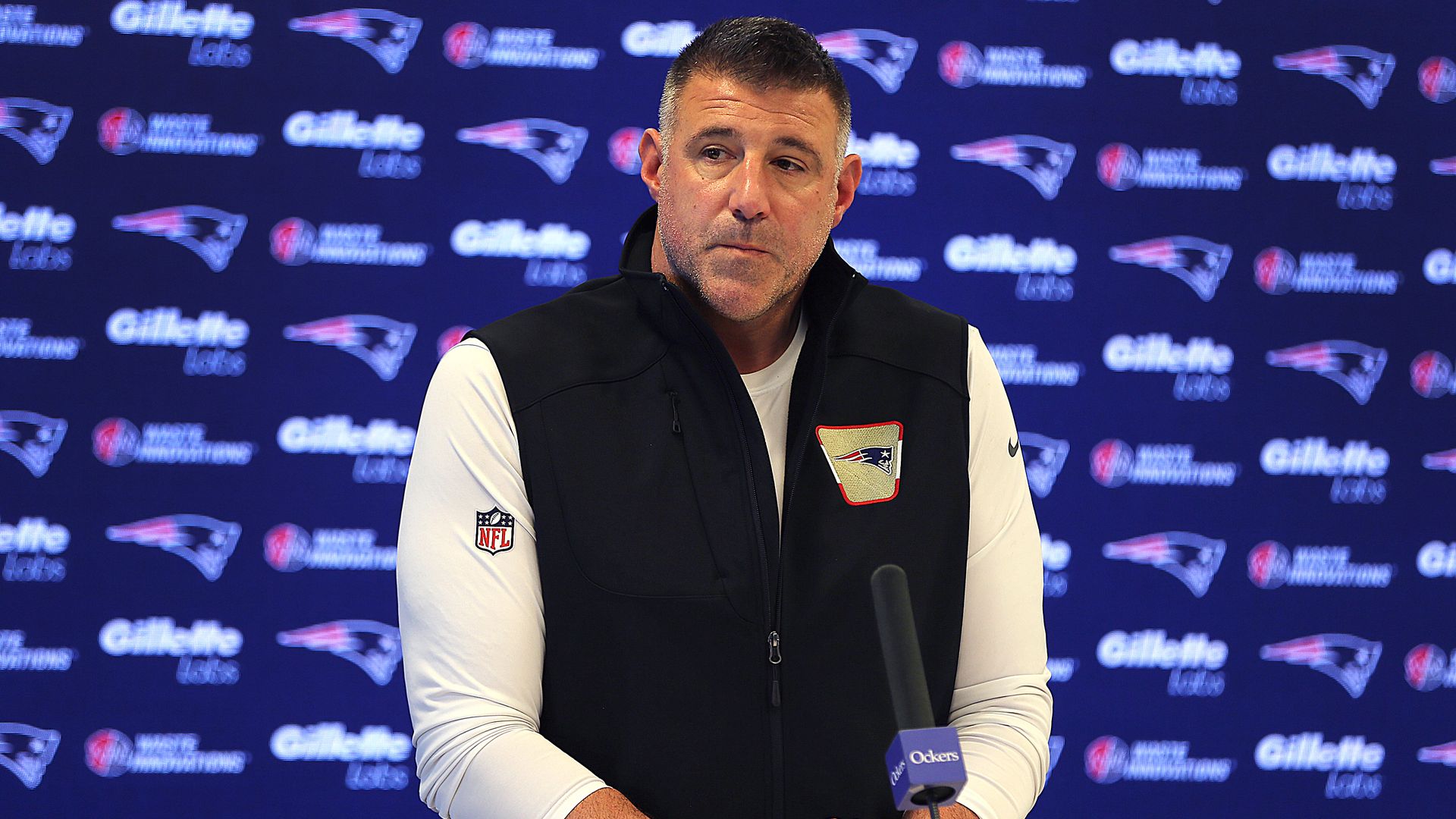 Patriots coach Mike Vrabel stands at a lectern and looks to his left during his last press conference of the 2025-26 NFL season at Gillette Stadium on Feb. 10, 2026.