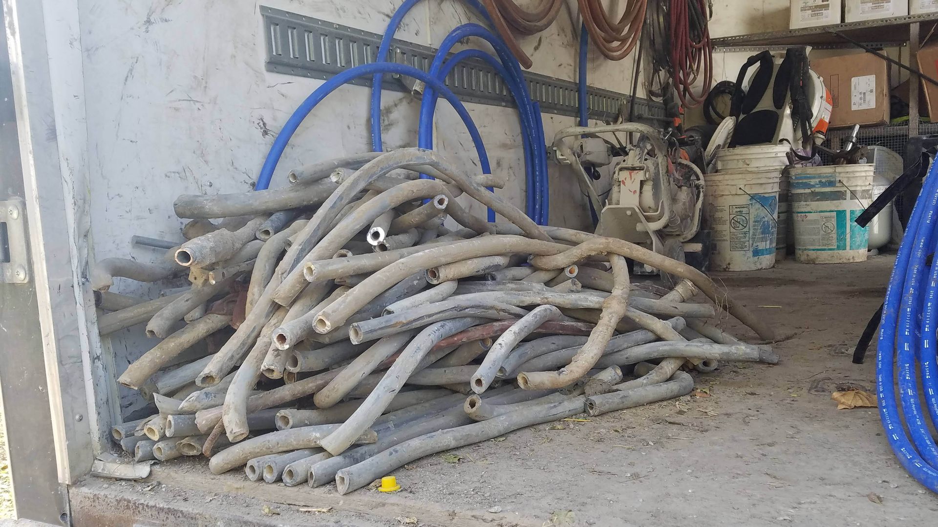 Photo of pipes piled up in a work space 