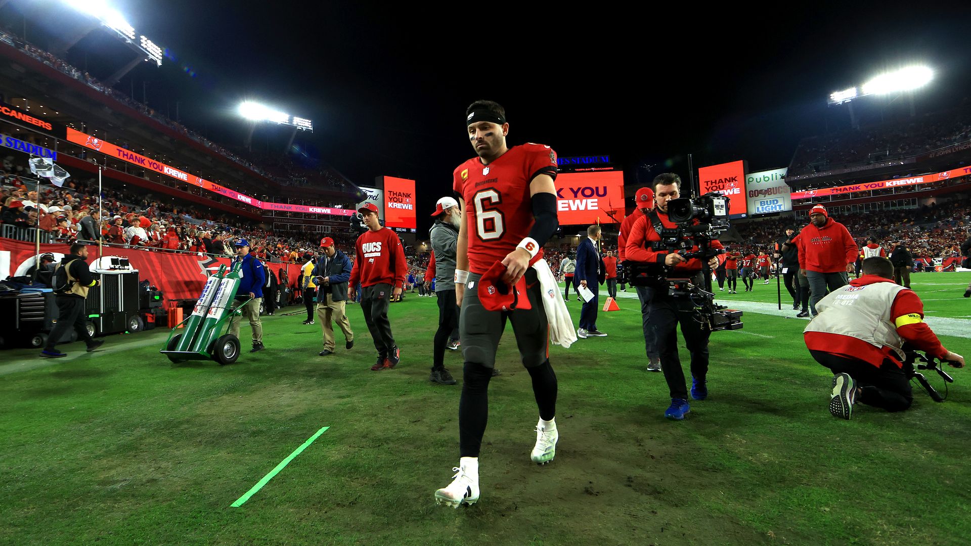 Bucs quarterback Baker Mayfield looks dejected as he walks off the field after losing to the Commanders.