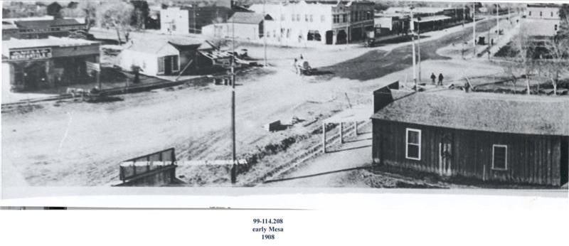A black and white photo showing a view of early down town from a distance. 