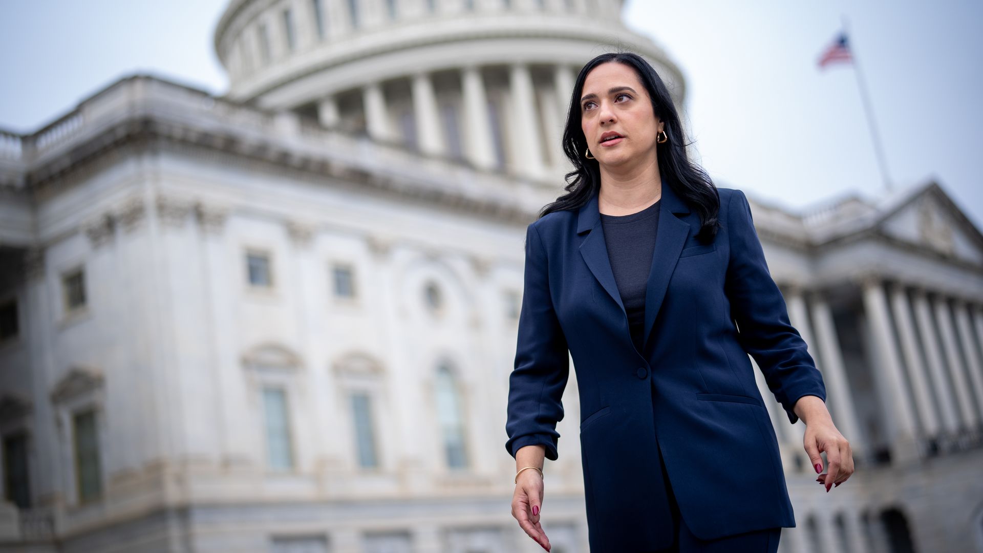 A woman walking in front of the U.S. Capitol. 