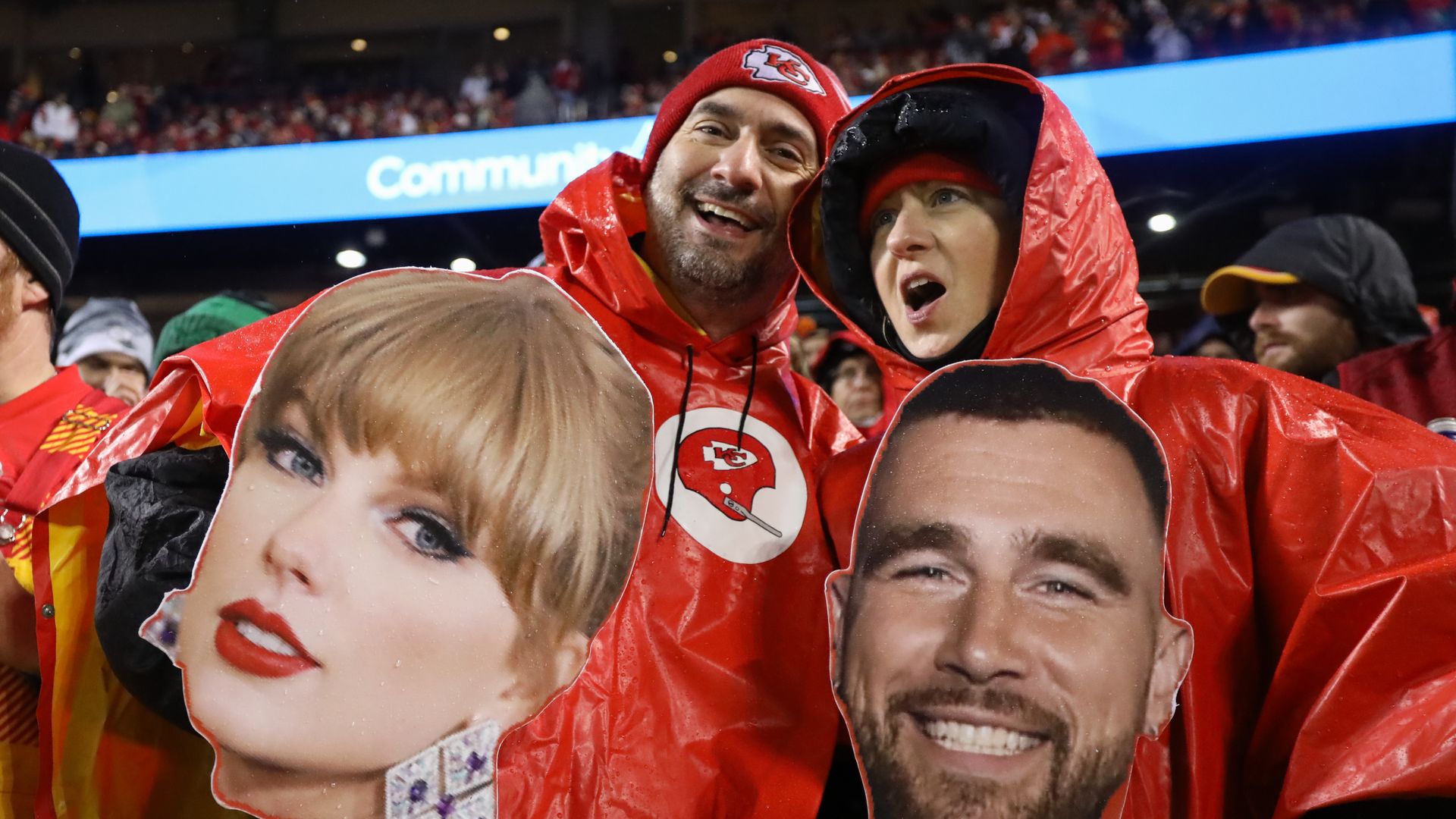 Fans hold up big-head cutouts of pop star Taylor Swift and Kansas City tight end Travis Kelce during the Eagles' game.