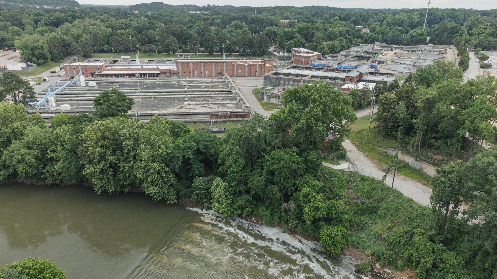 An aerial photo of a large wastewater treatment plant along a river