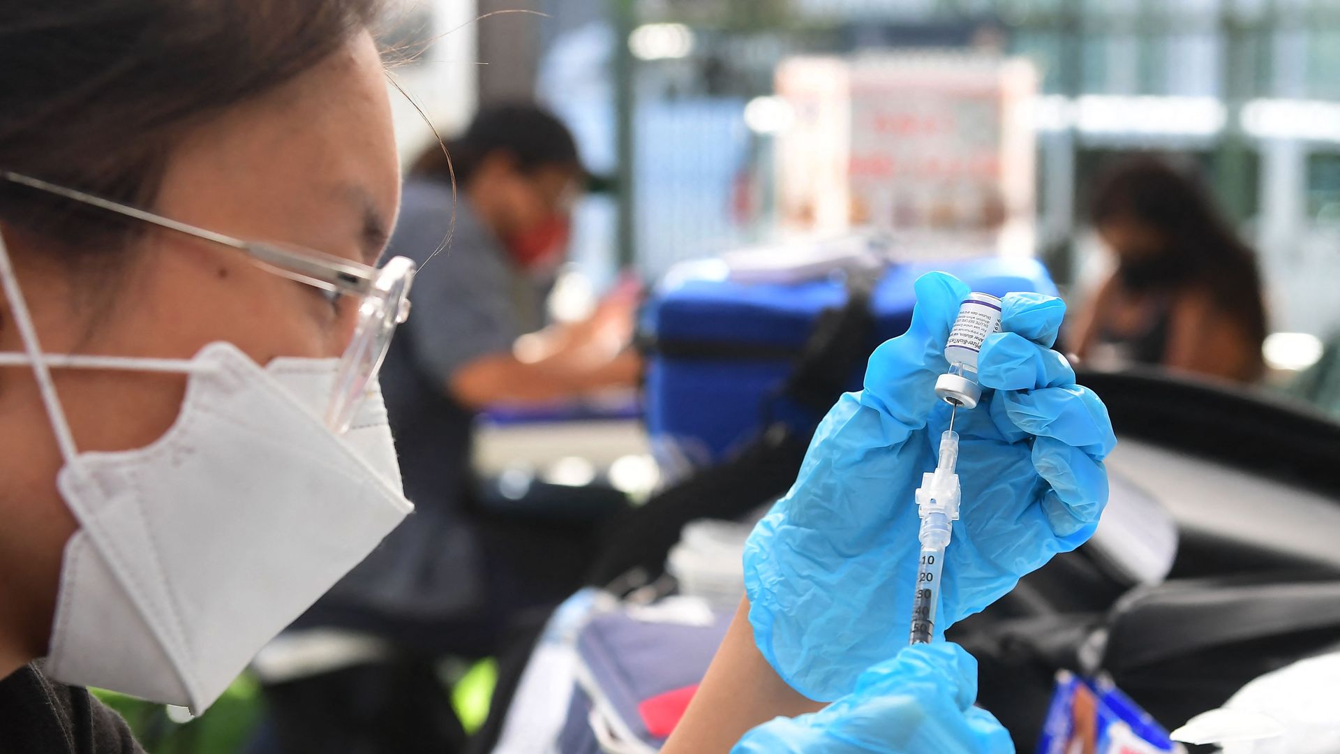 A woman fills a COVID-19 syringe.