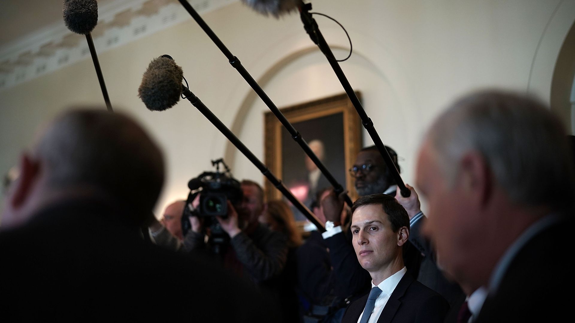 Jared Kushner amidst a sea of reporters with cameras and microphones