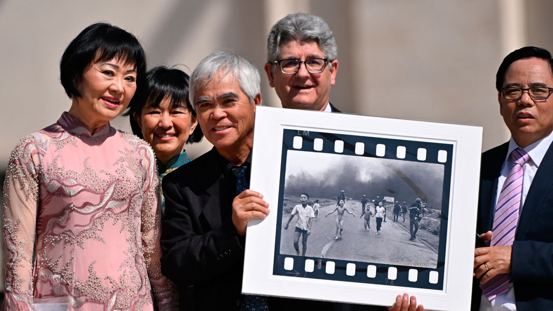 Retired AP photographer Nick Ut holds his Pulitzer and World Press Photo Award, 1972 photograph "Napalm Girl," depicting Kim Phuc, next to him, as they attend then-Pope Francis' weekly open-air general audience in St. Peter's Square on May 11, 2022, at the Vatican.