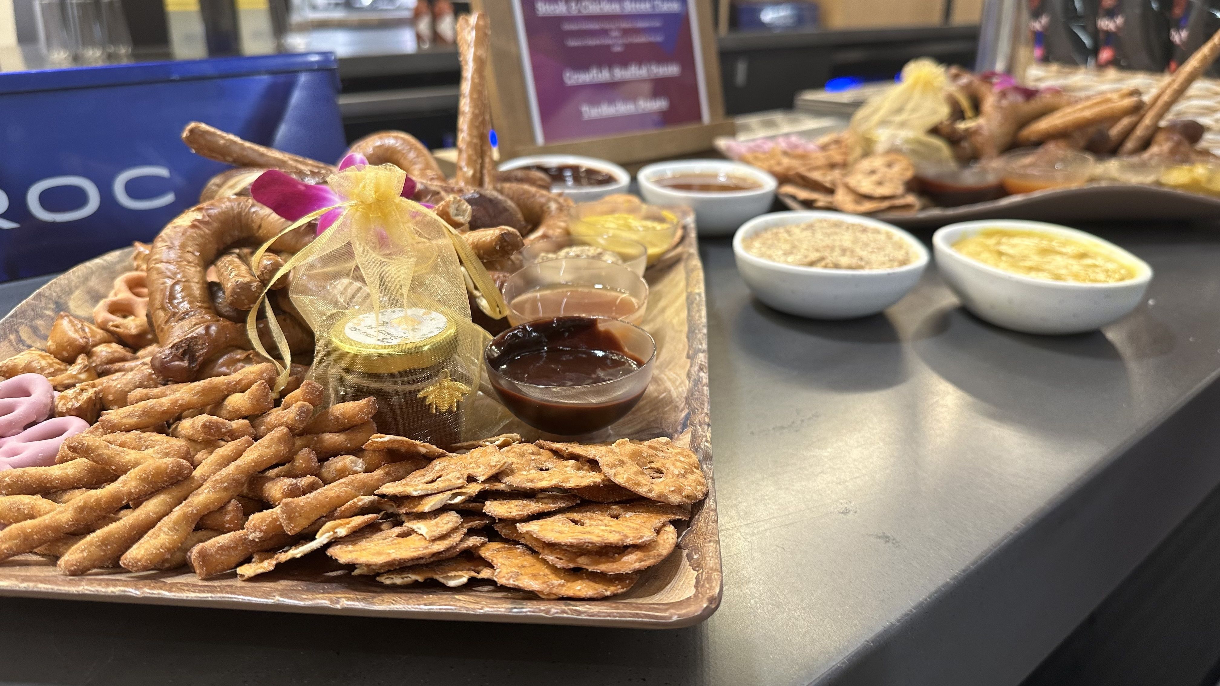 A platter of pretzels and pretzel chips sits next to bowls of dips.