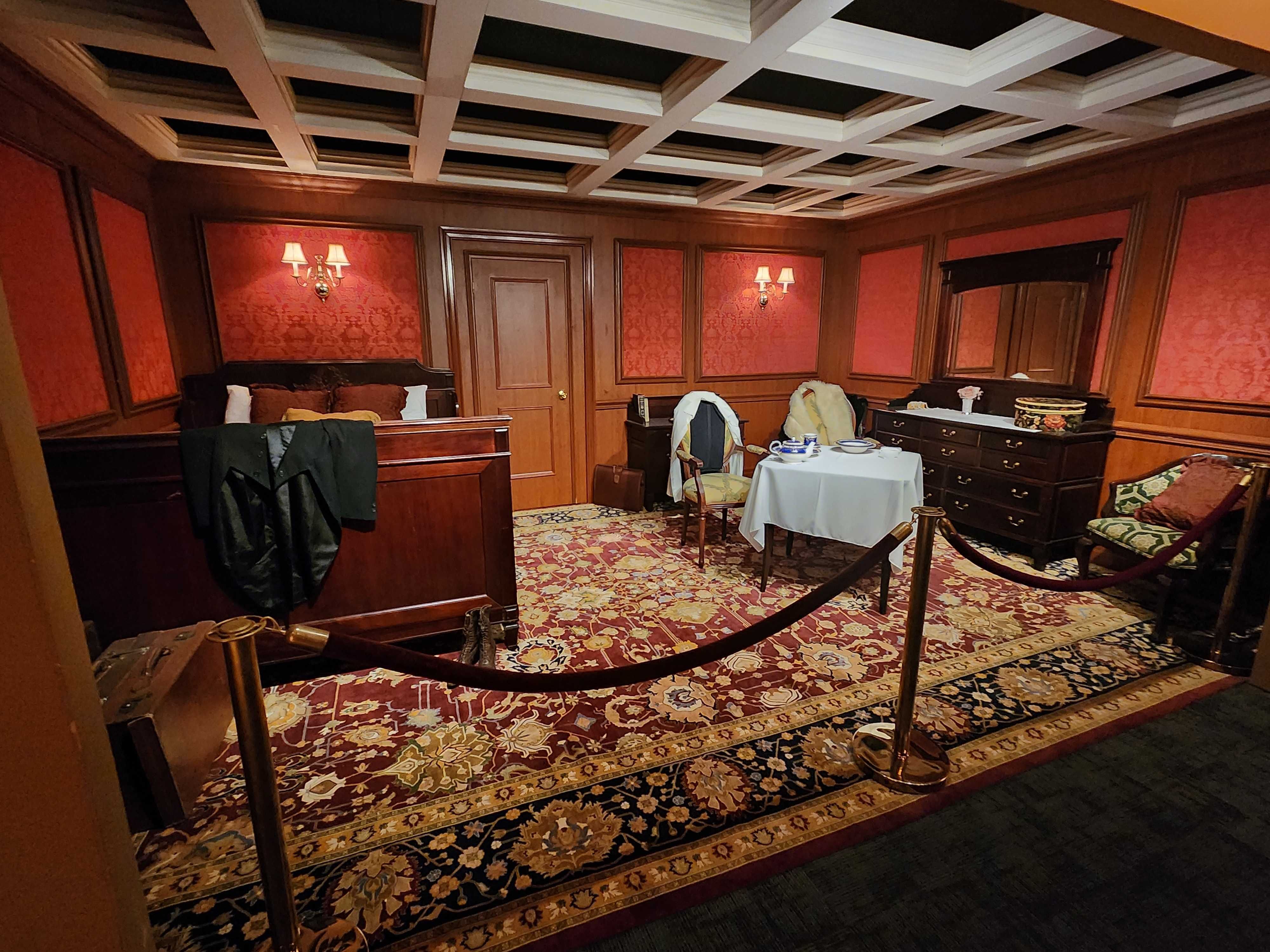 A recreated room as it would have looked like on the Titanic, with a bed, chairs, desks and carpet. 