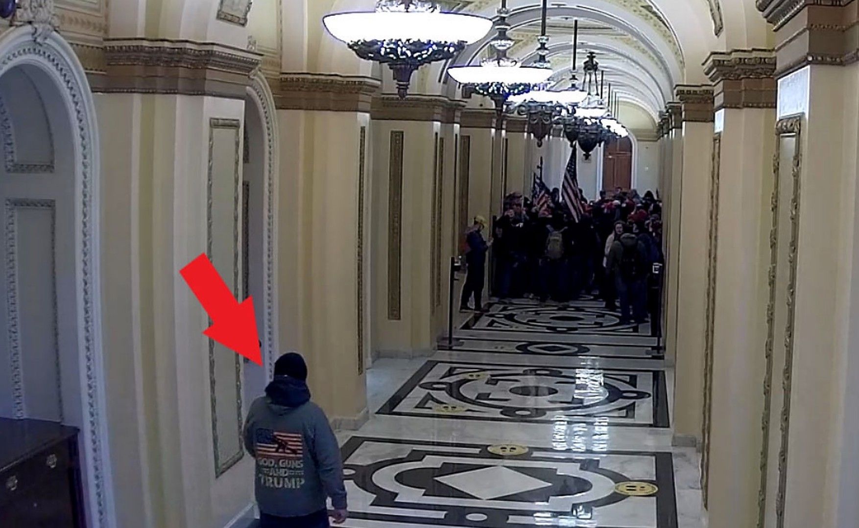 A photo of Capitol rioter Jeffrey Register wearing a "God, Guns & Trump" sweatshirt in the U.S. Capitol building.