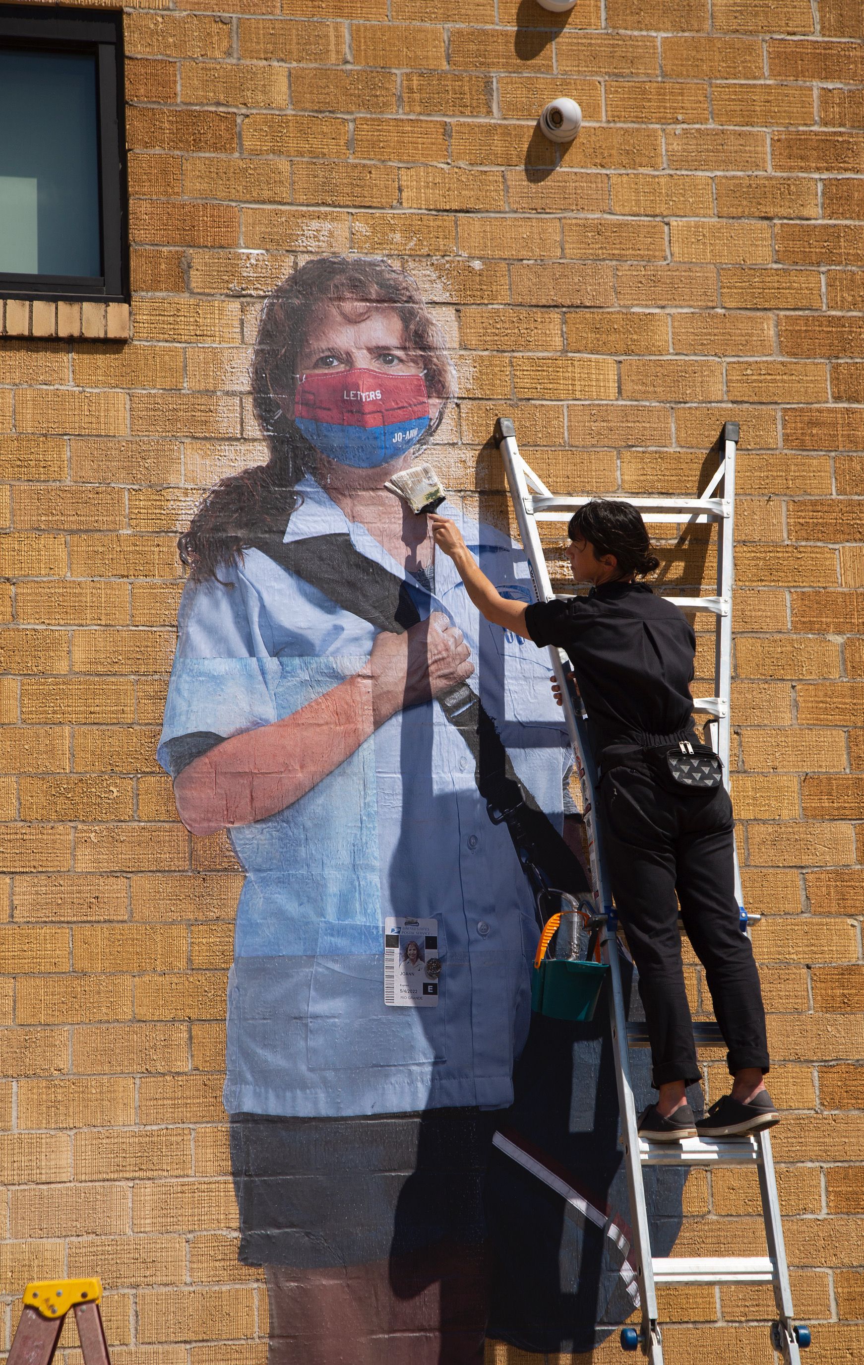Sarah Wilson assembles one of her essential women worker murals in Austin.