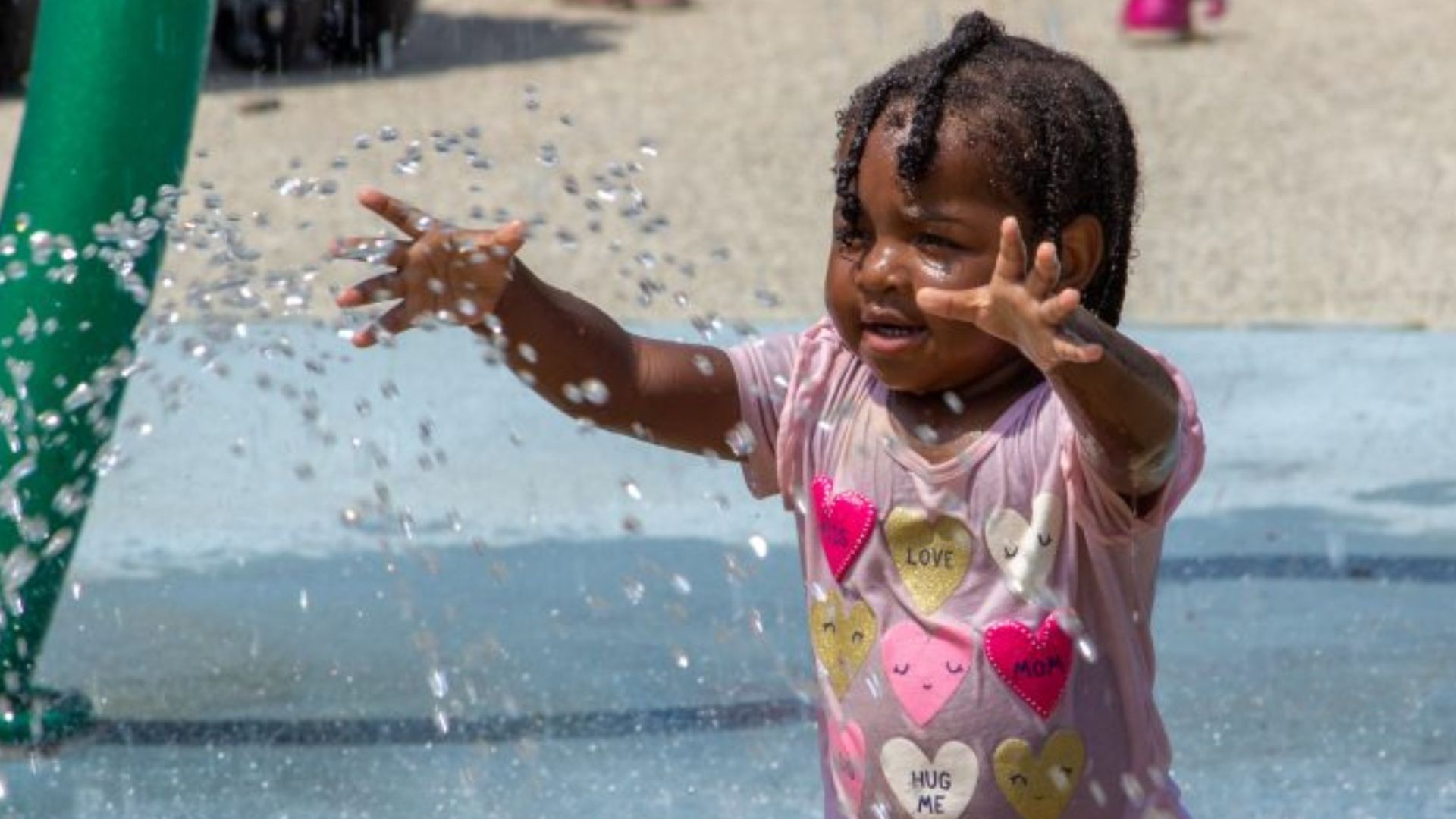 A young girl living it up at Joseph E. Mander Playground's spray grounds.  