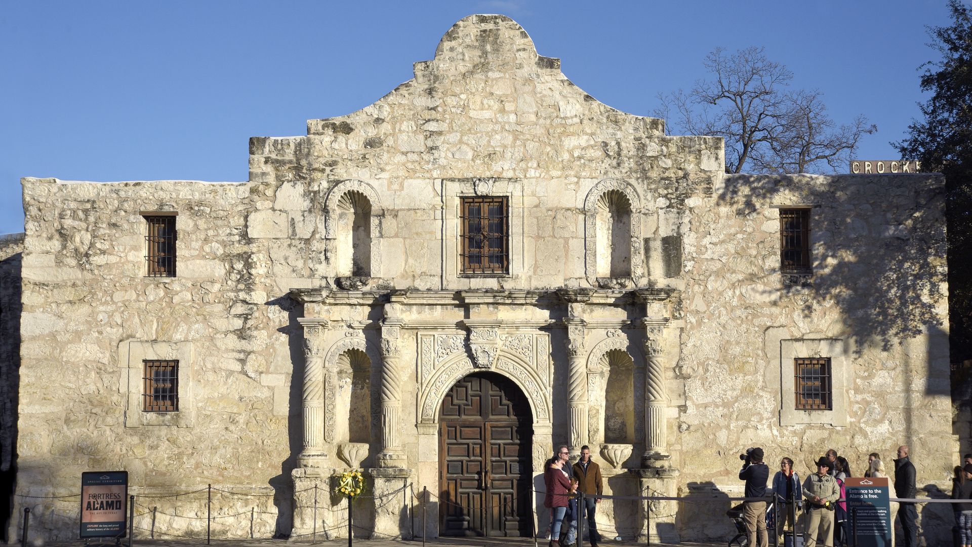 Tourists pose for a souvenir photograph in front of Mission San Antonio de Valero, better known as The Alamo.