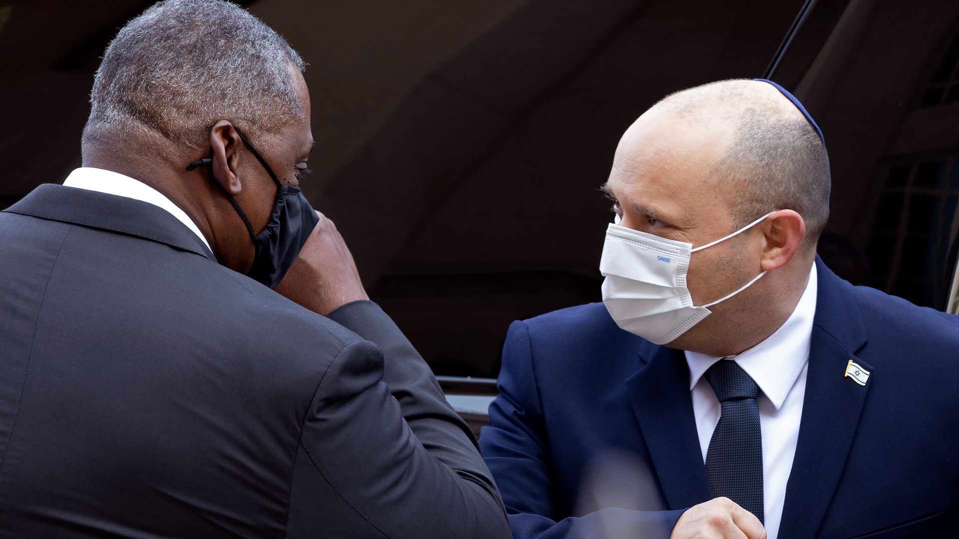 Photo of a masked Lloyd Austin and Naftali Bennett touching elbows 