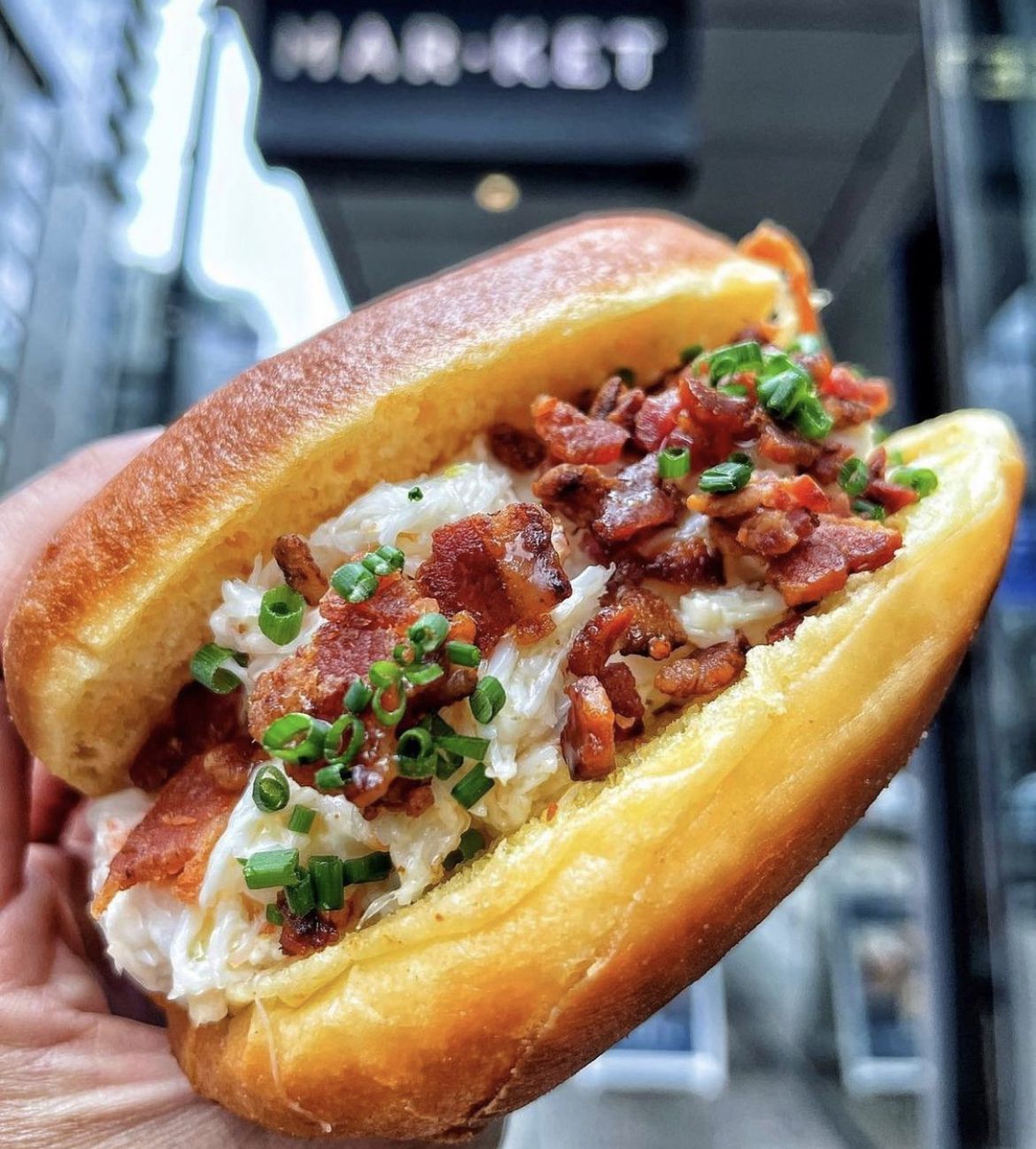 A crab roll loaded with bacon.