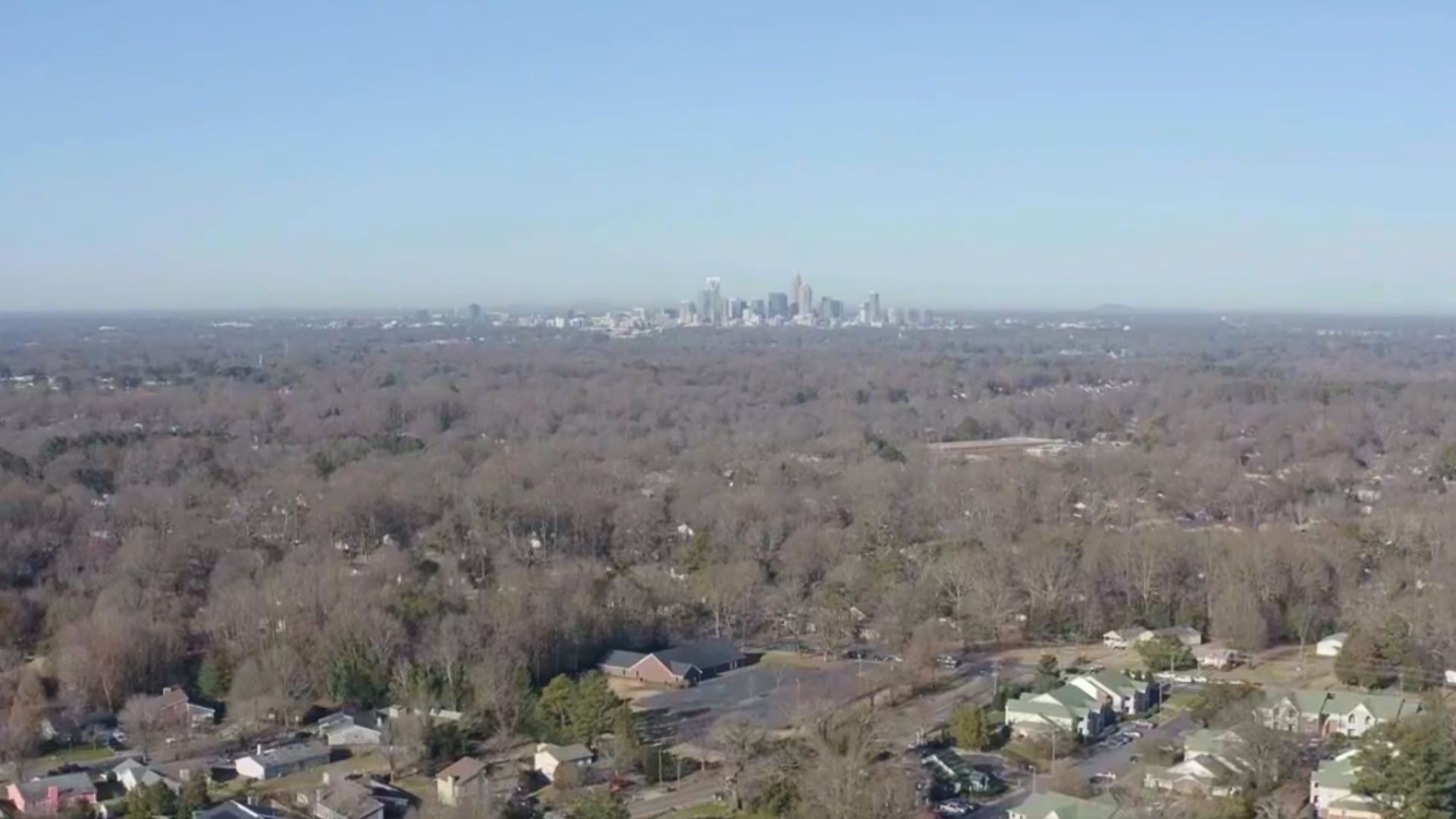 Aerial view of city with trees and houses below.