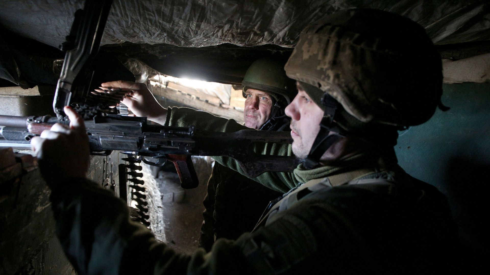 Ukrainian soldiers loading a machine gun in a trench in the Donetsk region on February 19.