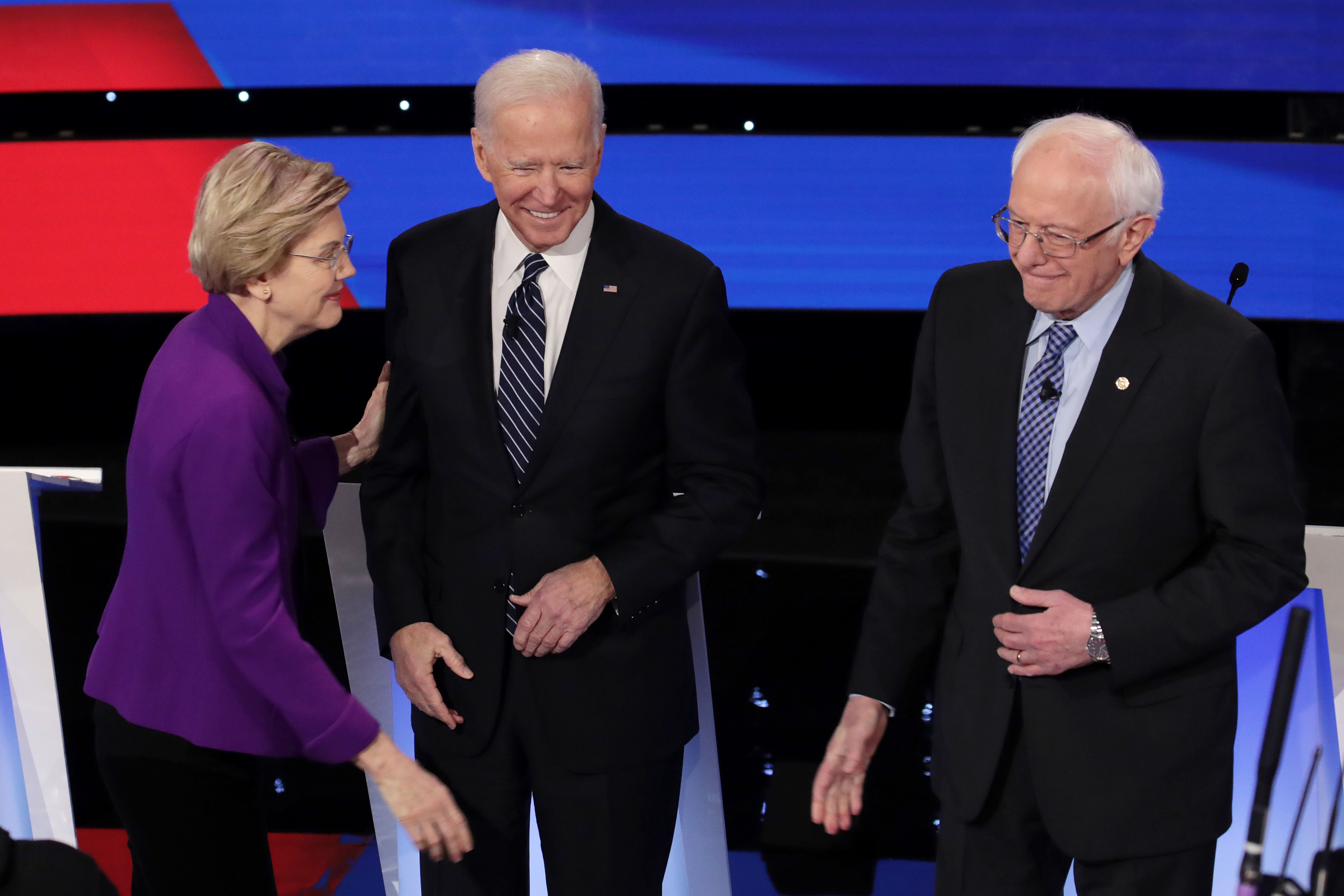 : Sen. Elizabeth Warren (D-MA) greets former Vice President Joe Biden (C) and Sen. Bernie Sanders (I-VT) ahead of the Democratic presidential primary debate