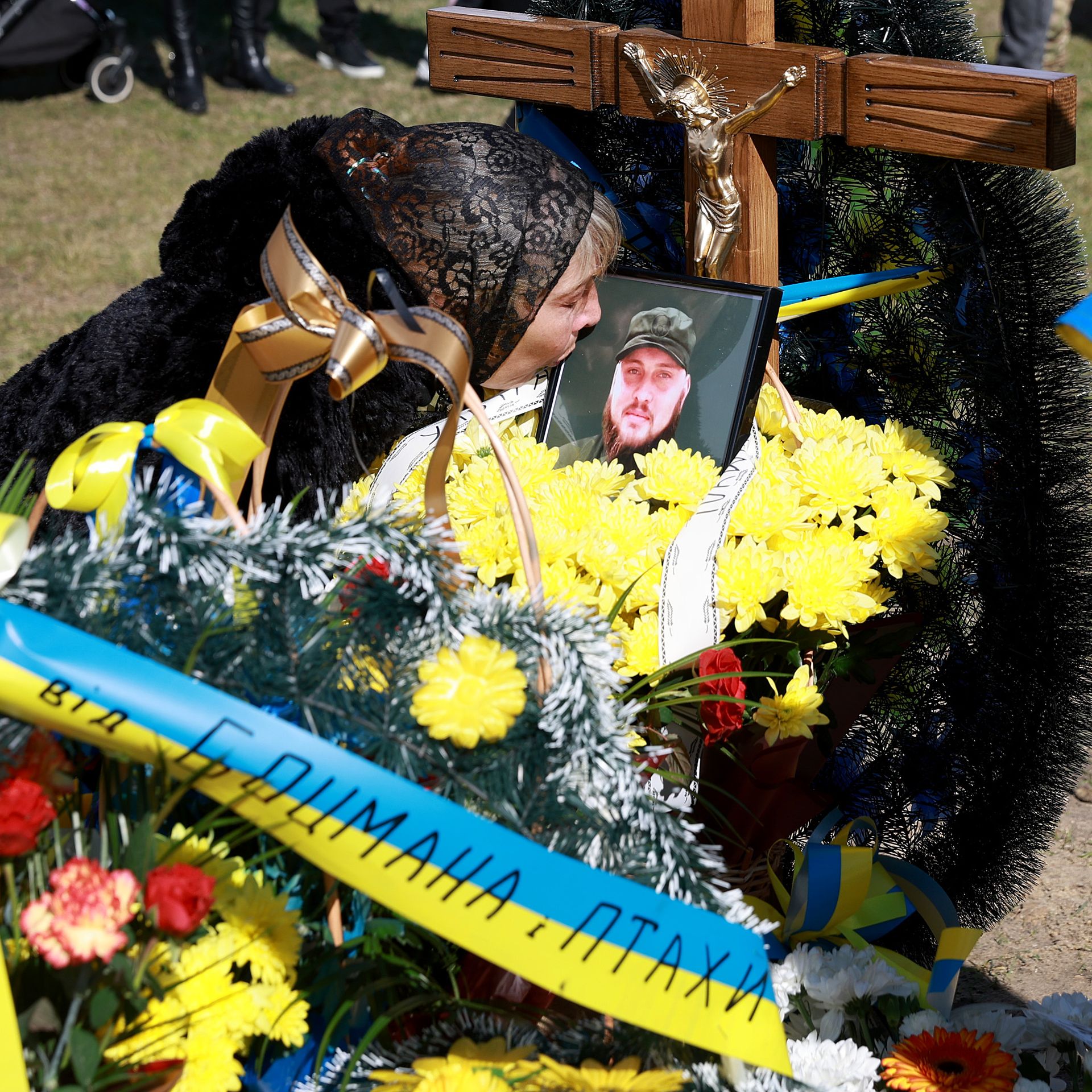 A mother kisses a photo of her son as he was buried after being killed fighting the Russians in eastern Ukraine.