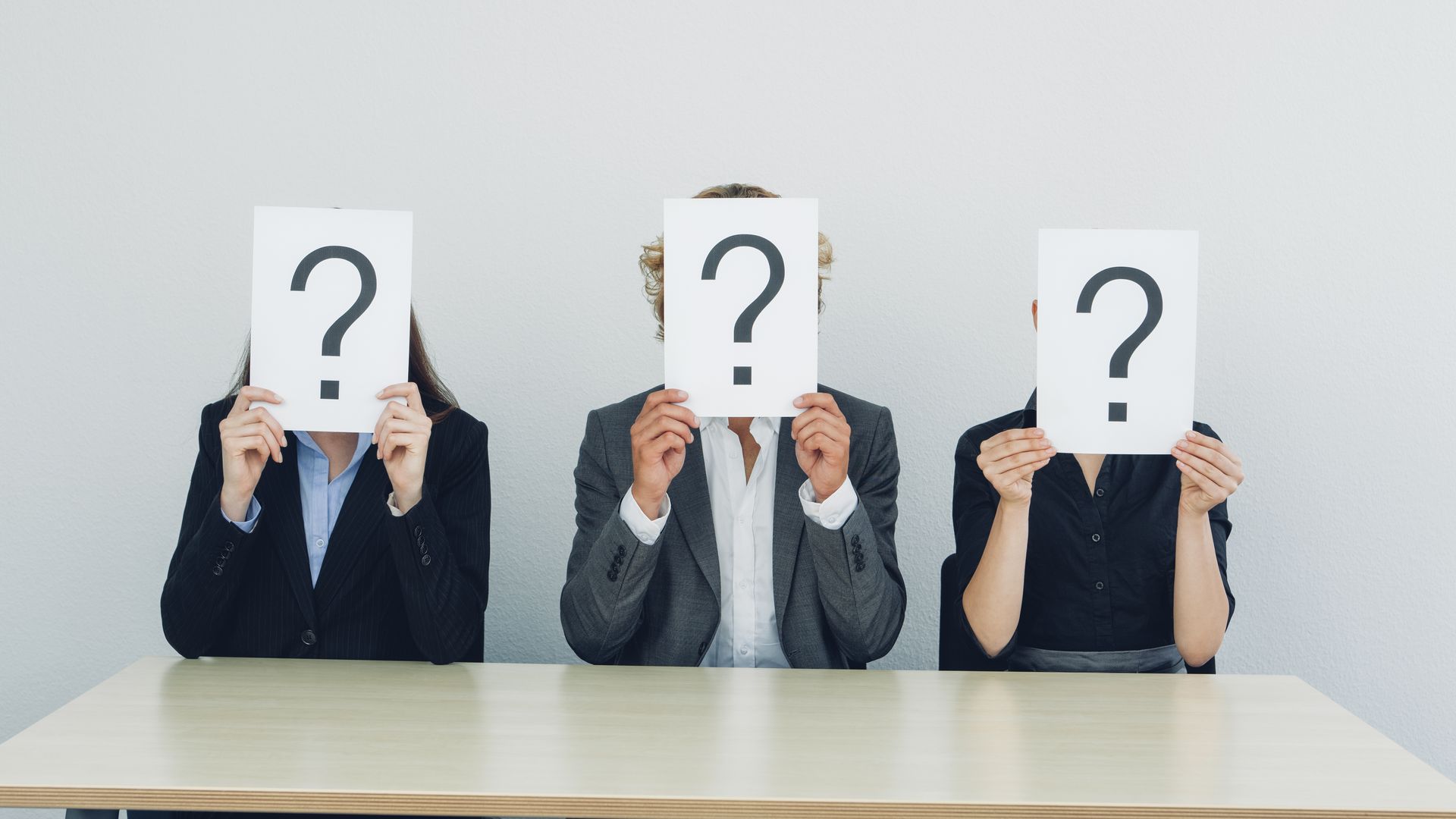 Businesspeople with question marks for heads