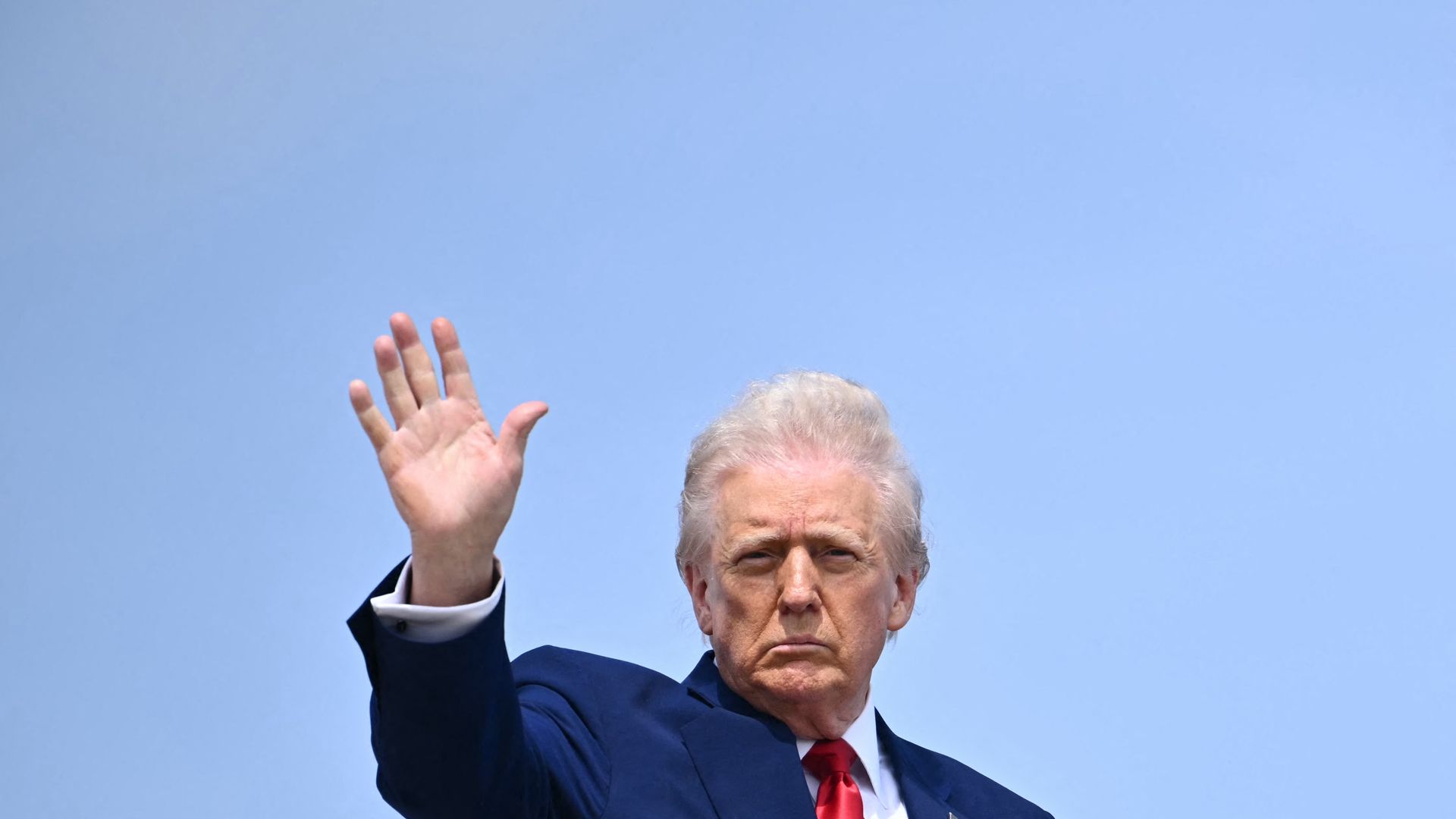 Trump waives from the top of the Air Force One stairs