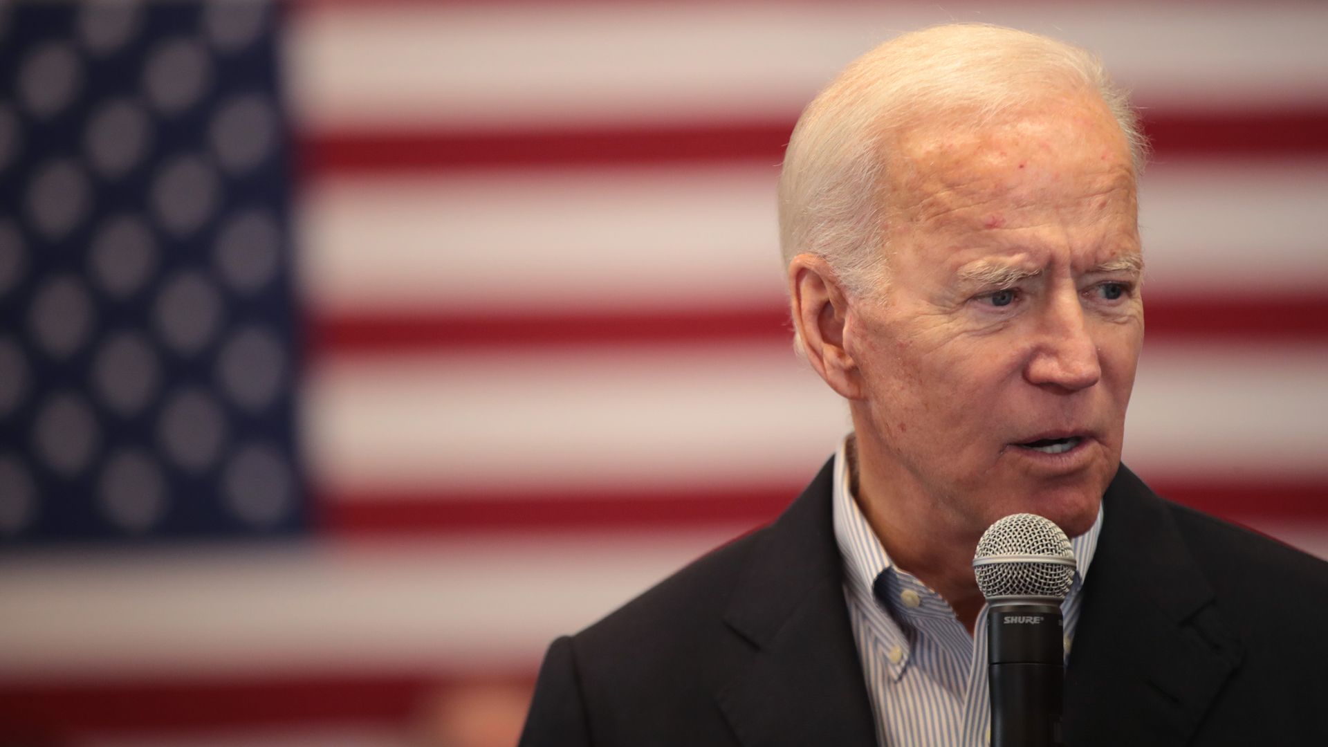 In this image, Biden speaks into a microphone.